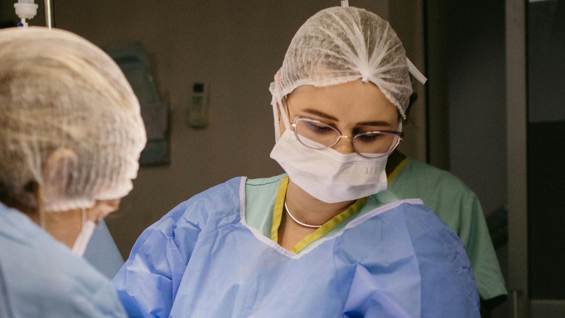 Medical professionals performing surgery in a hospital operating room, showcasing teamwork and precision.