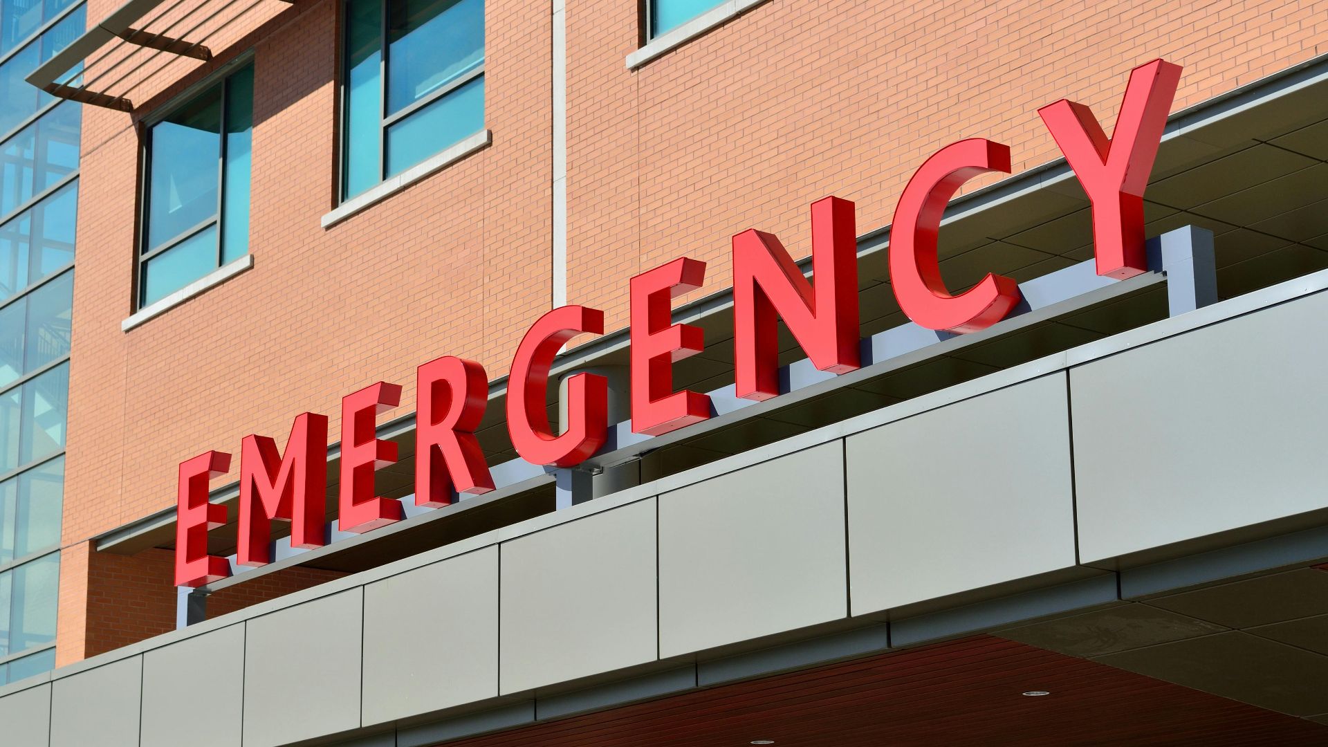Close-up of a modern hospital emergency room entrance with prominent red letters.