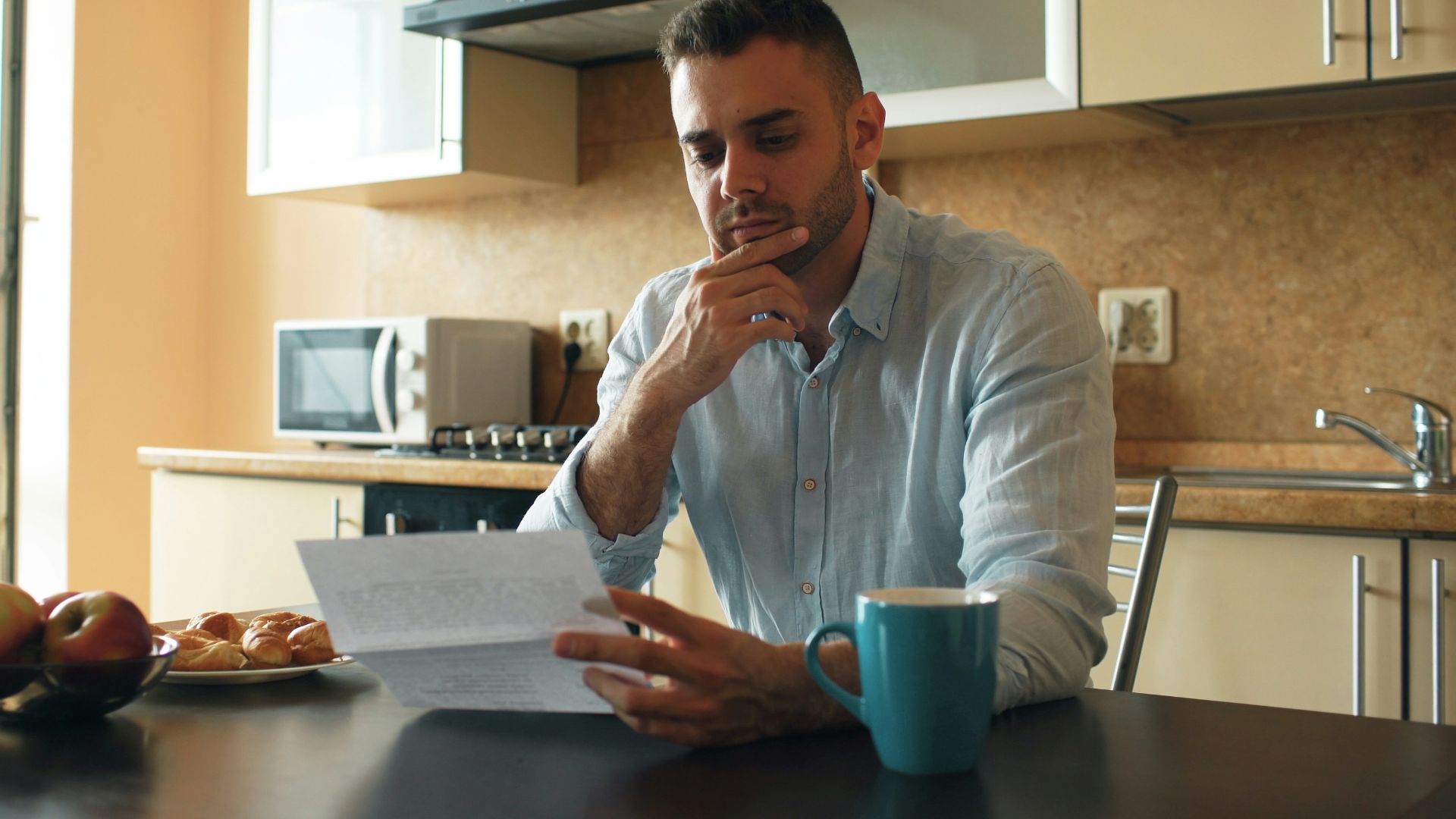 Man reading a document in a kitchen