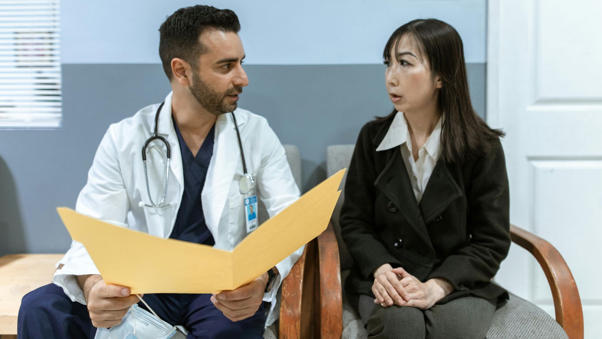 Healthcare professional consults patient in clinical setting. Medical discussion and diagnosis.