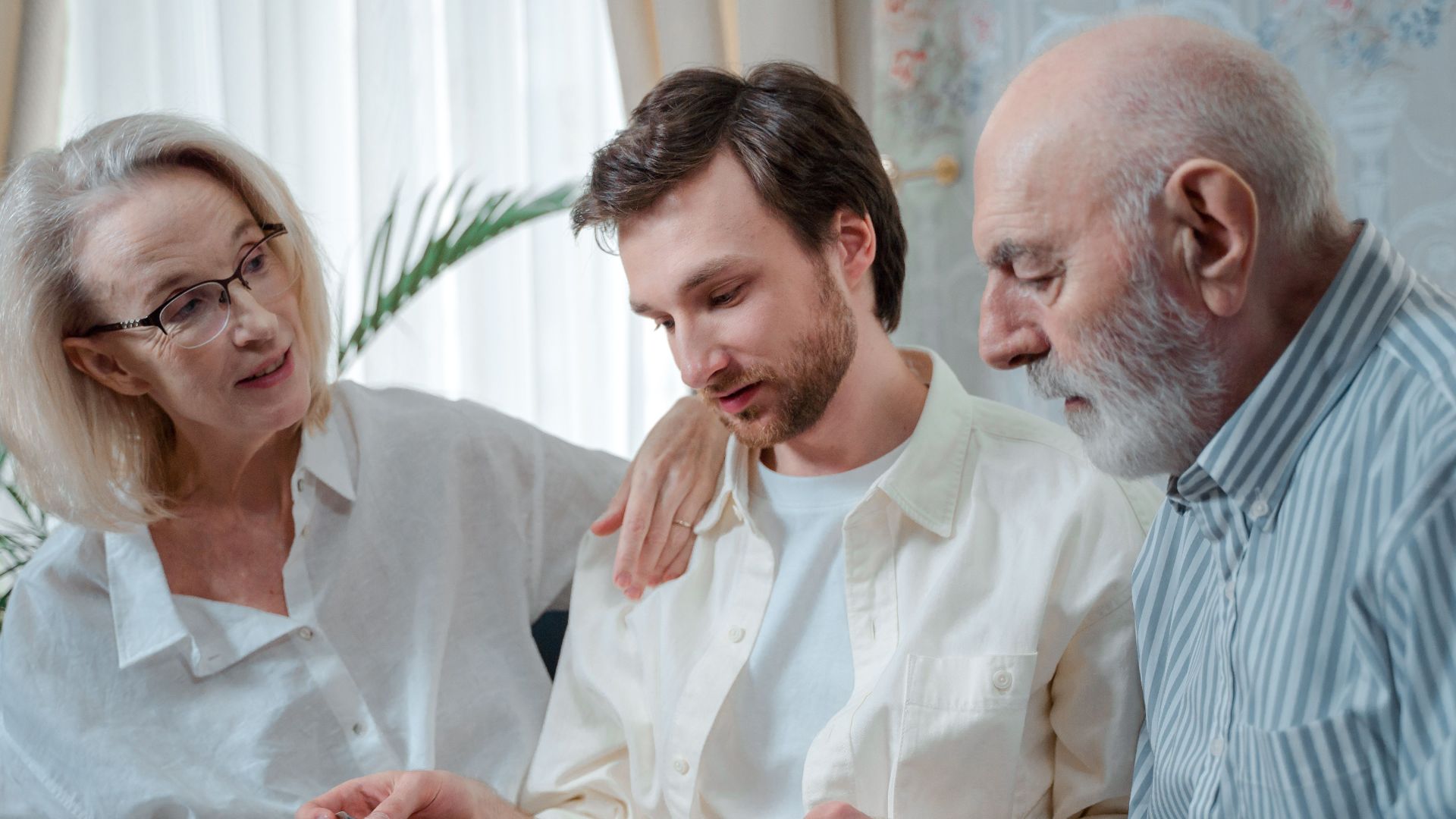 A family looks through a photo album, cherishing memories together indoors.