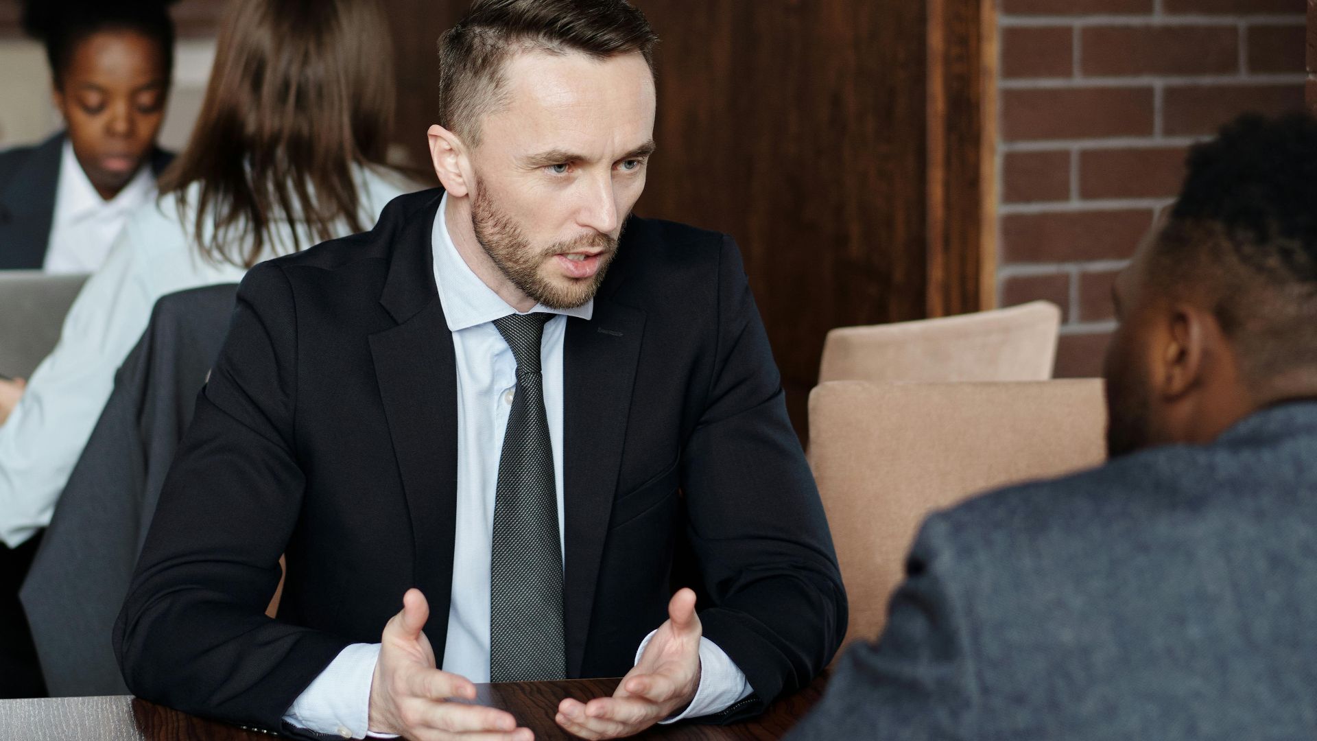 Professionals in suits having a focused business discussion in a stylish café.