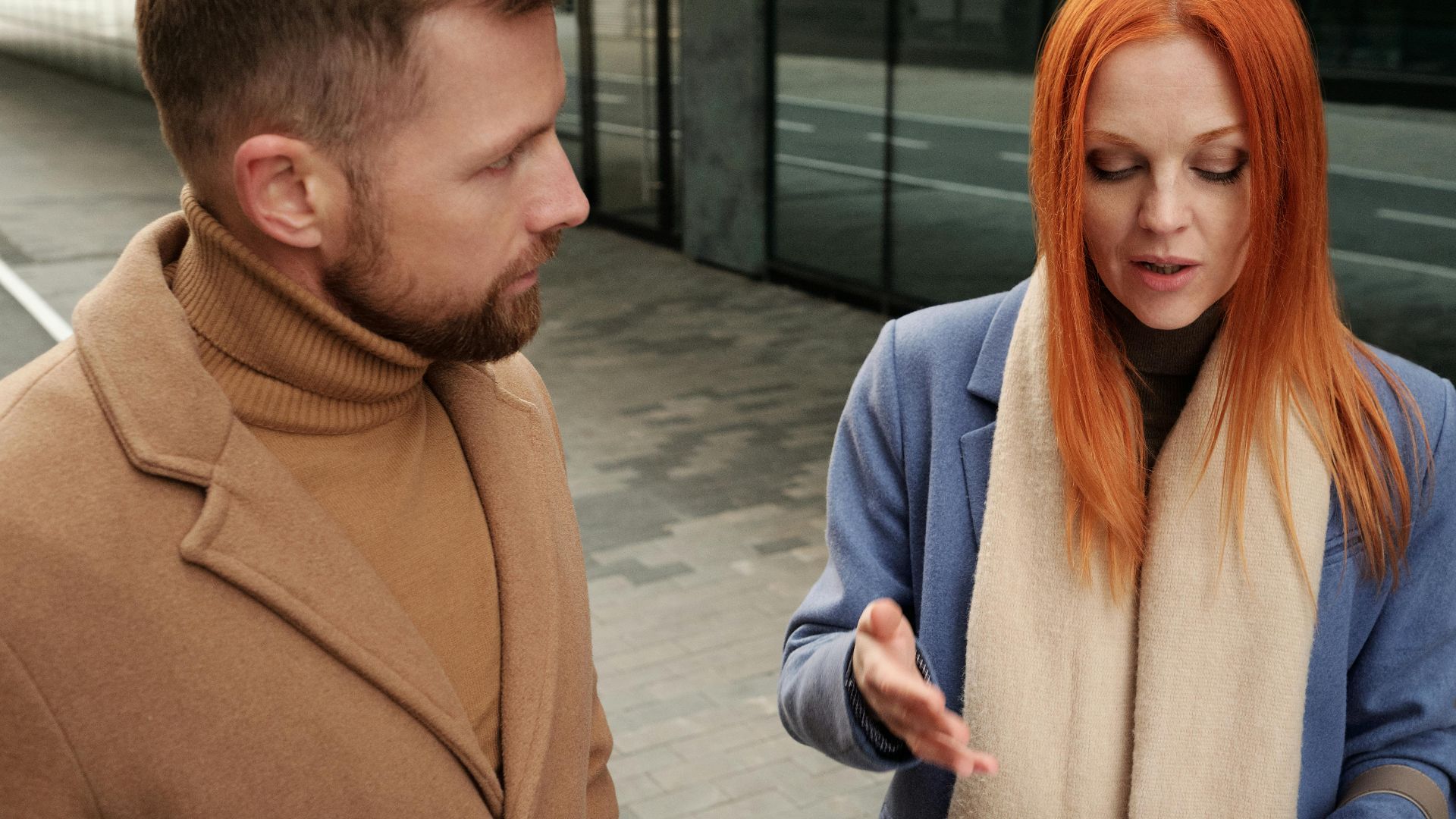 Two professionals engaged in a serious discussion, reviewing documents outdoors.