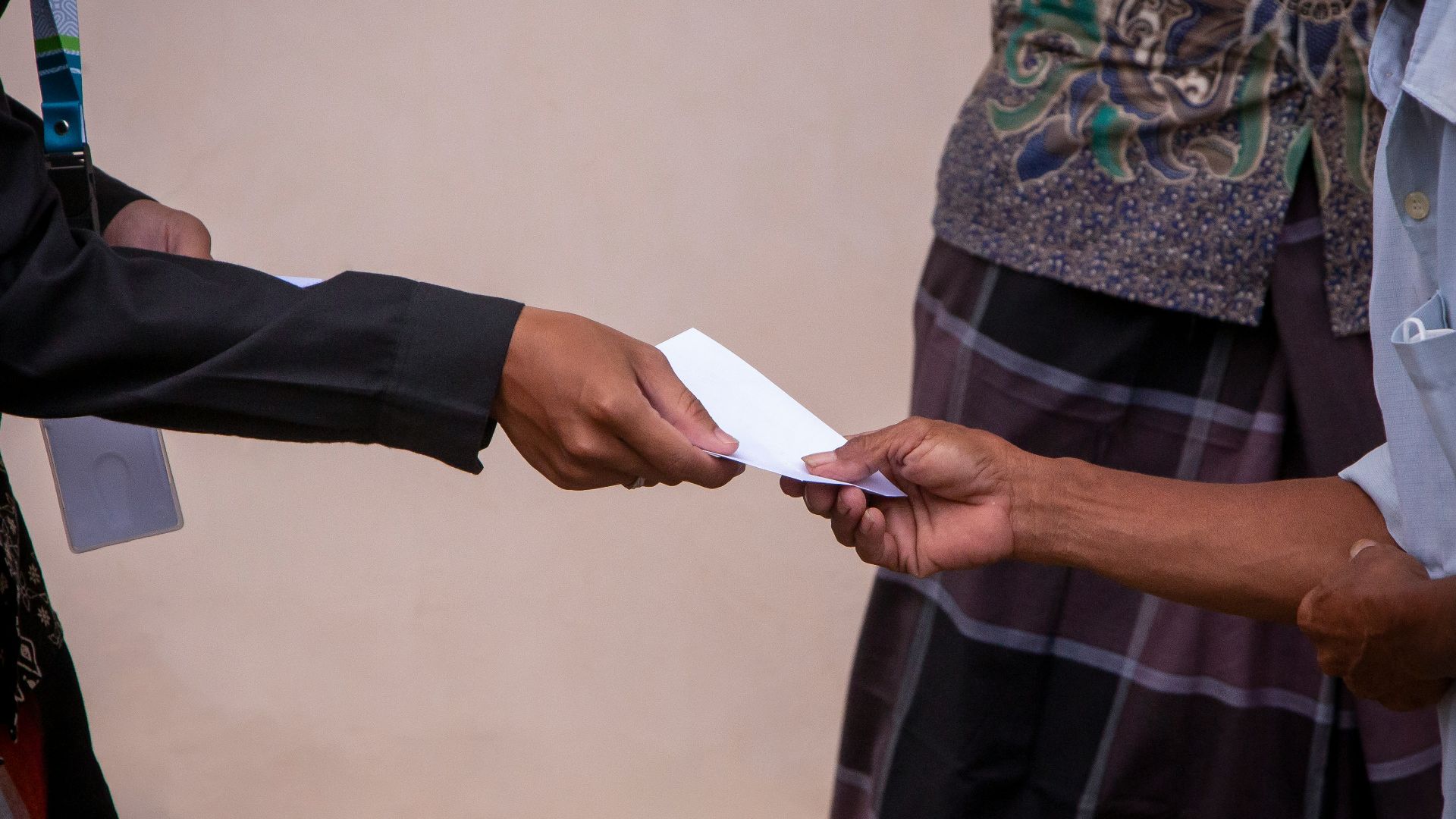 a person handing another person a piece of paper