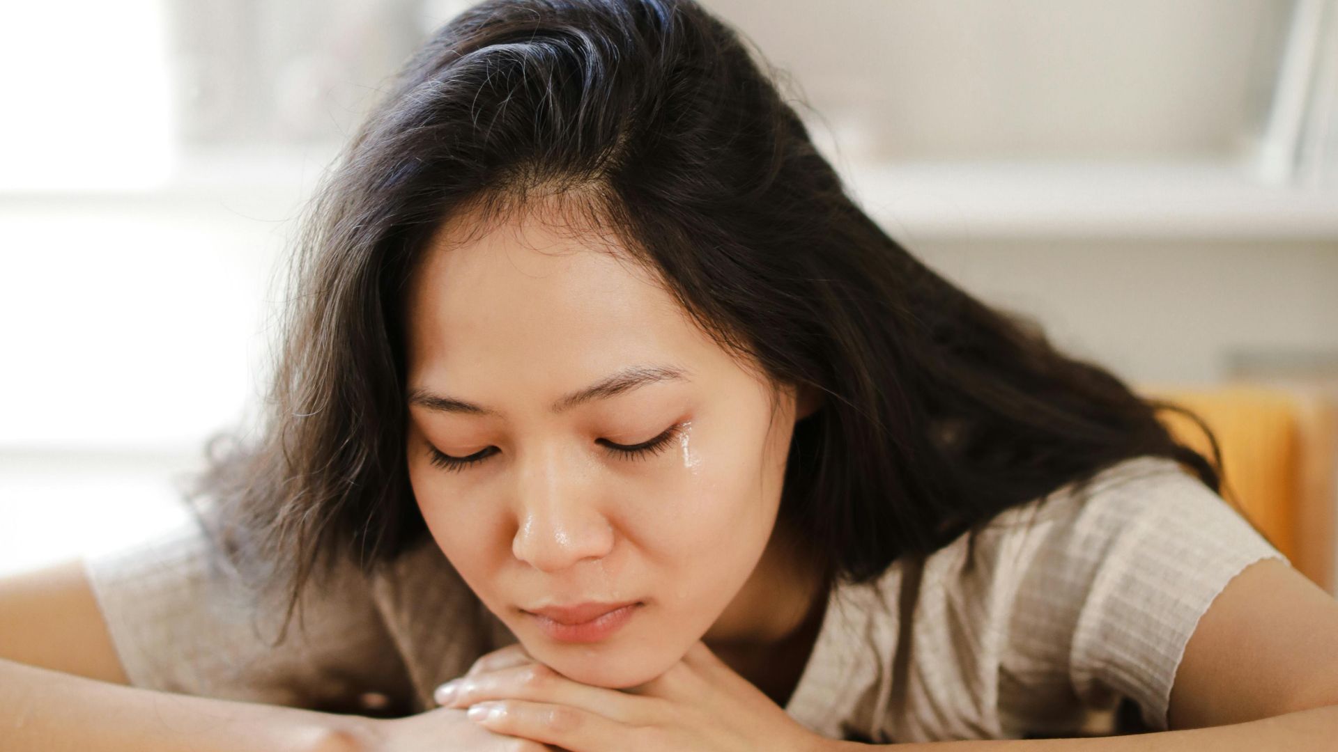 Thoughtful woman looking at a wedding ring, conveying relationship contemplation and emotional depth.