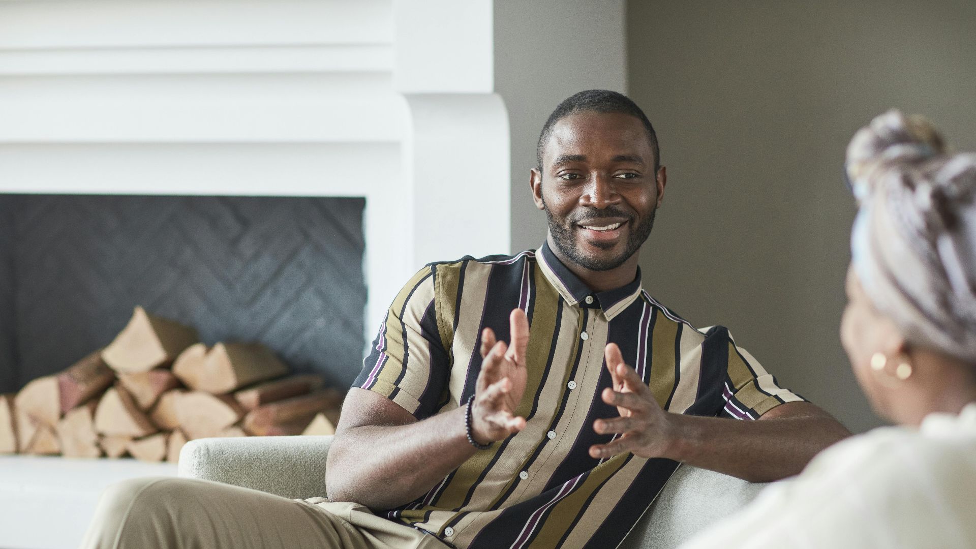 Two adults enjoying a friendly conversation in a cozy modern living room setting.