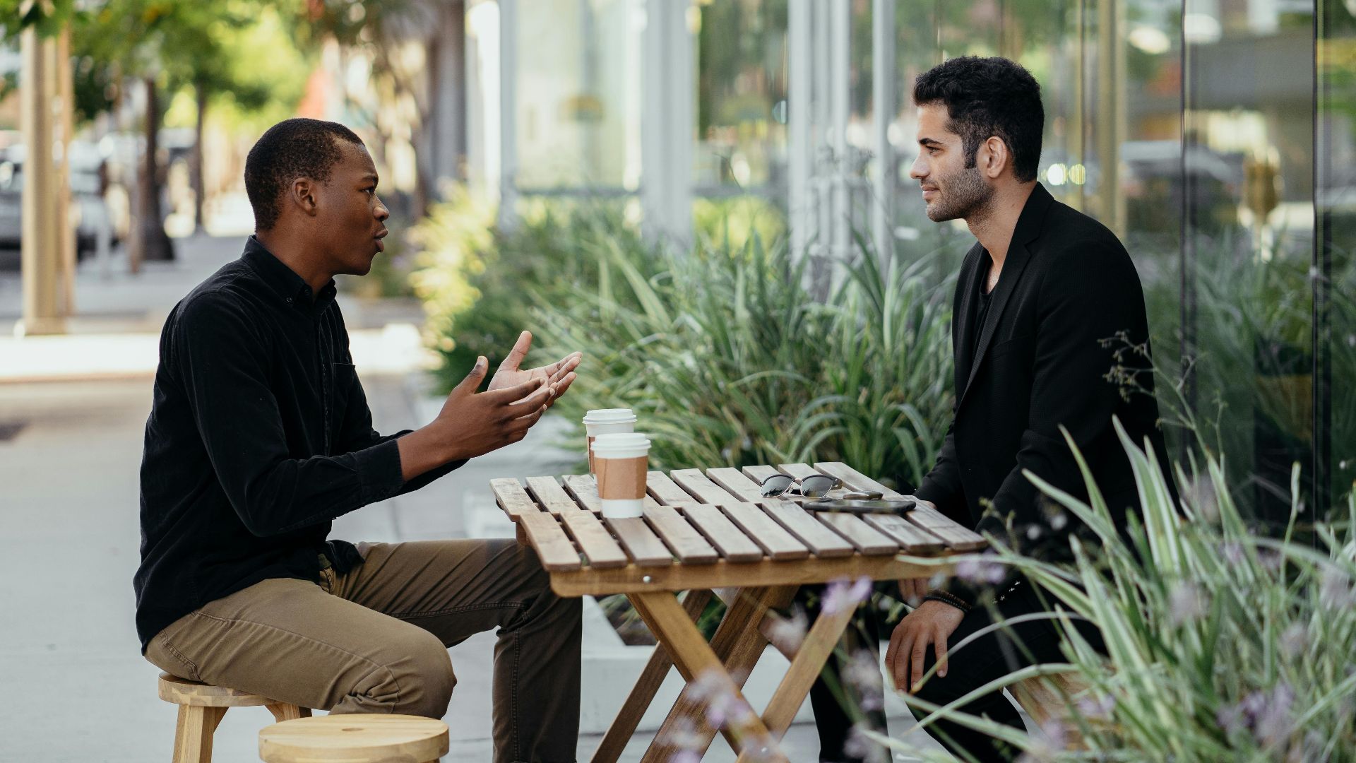 Two men having a business meeting at an outdoor café setting.