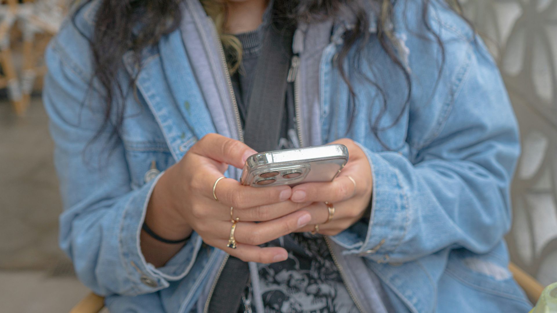 A woman sitting in a chair looking at her cell phone