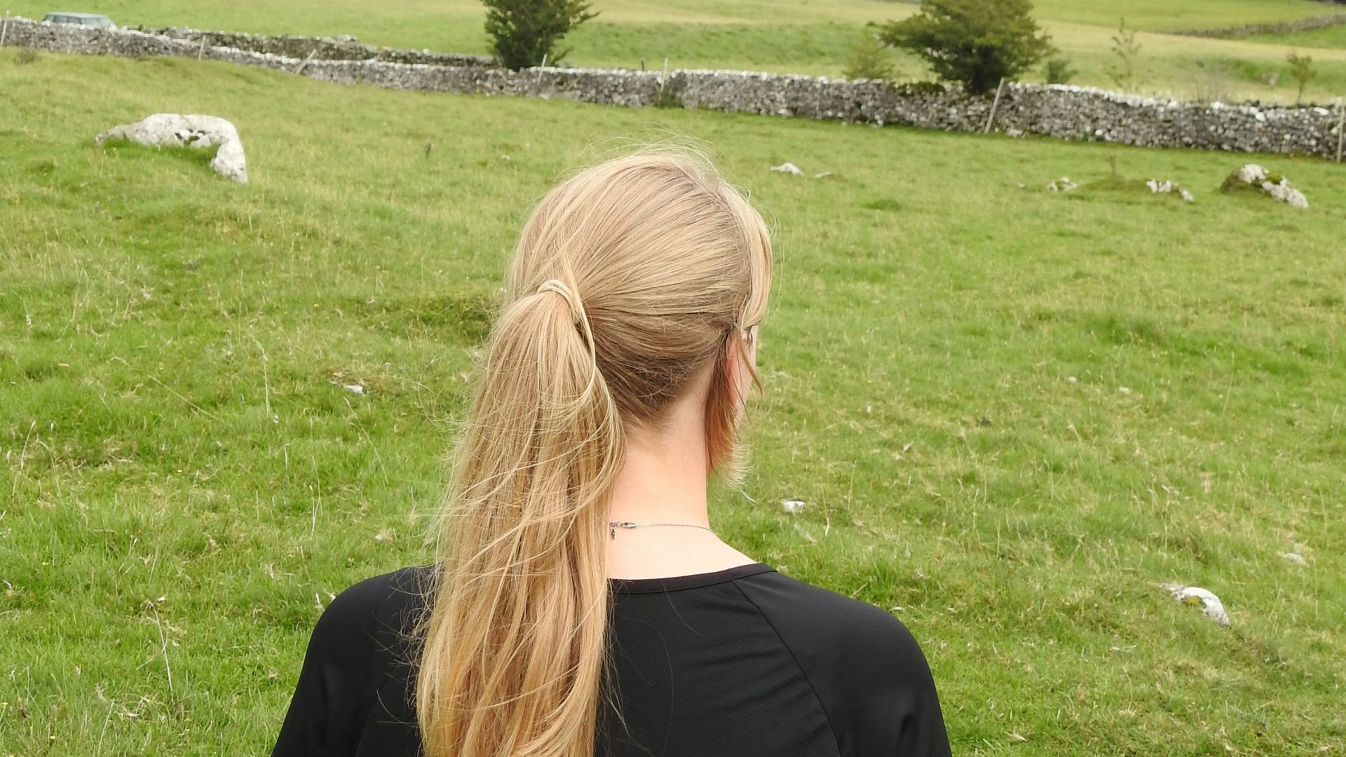 woman in black shirt standing on green grass field during daytime