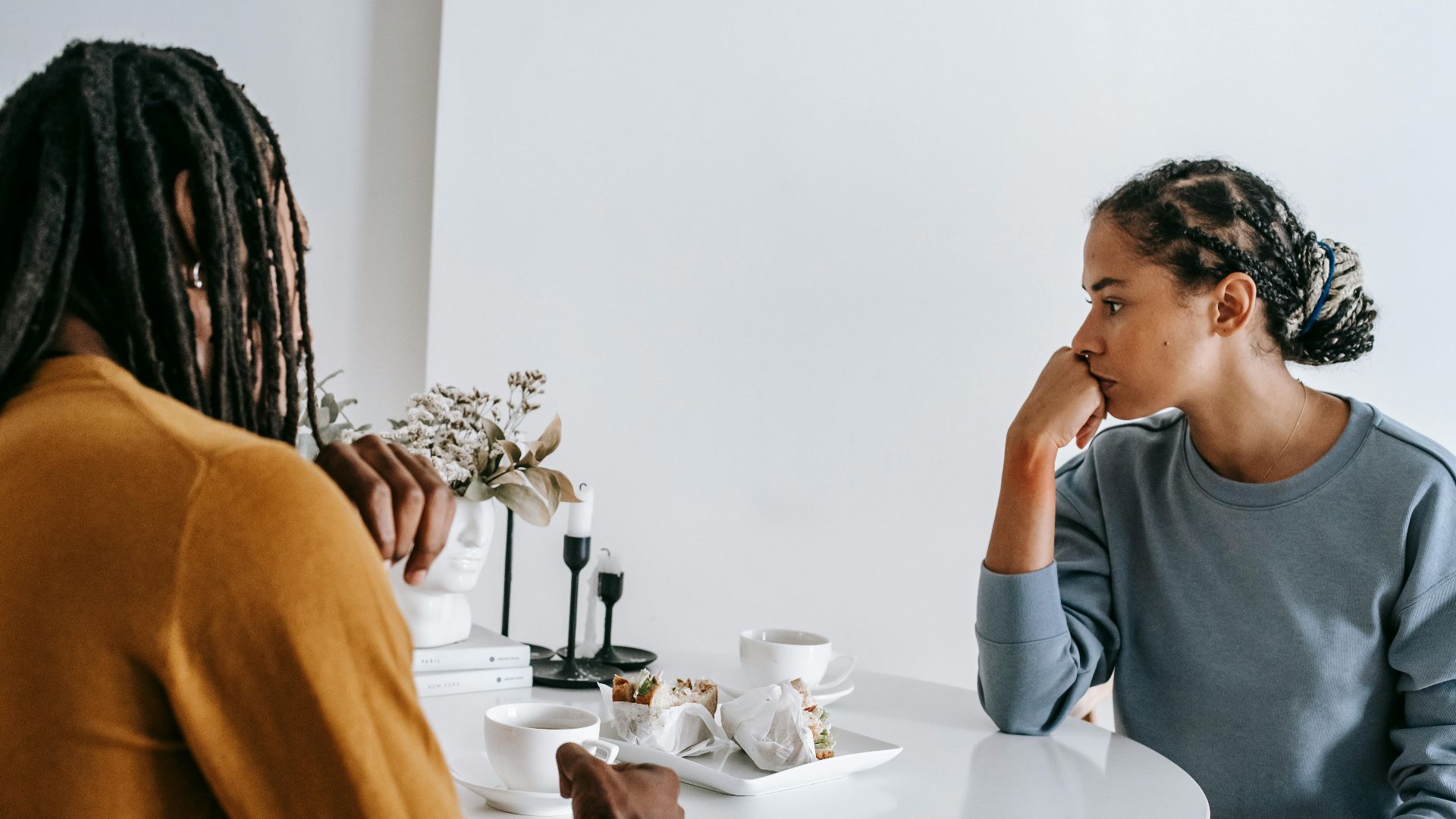 Young African American man sitting with woman at table and having conflict with each other at home
