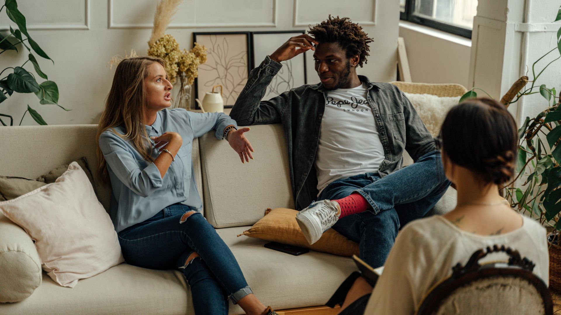 A couple is engaged in a lively conversation during a therapy session with a counselor.