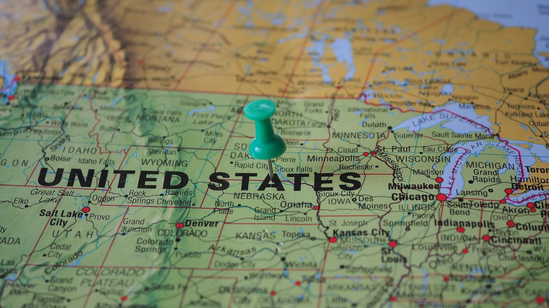 High-angle view of a map featuring the United States with a green pin indicating a specific location.