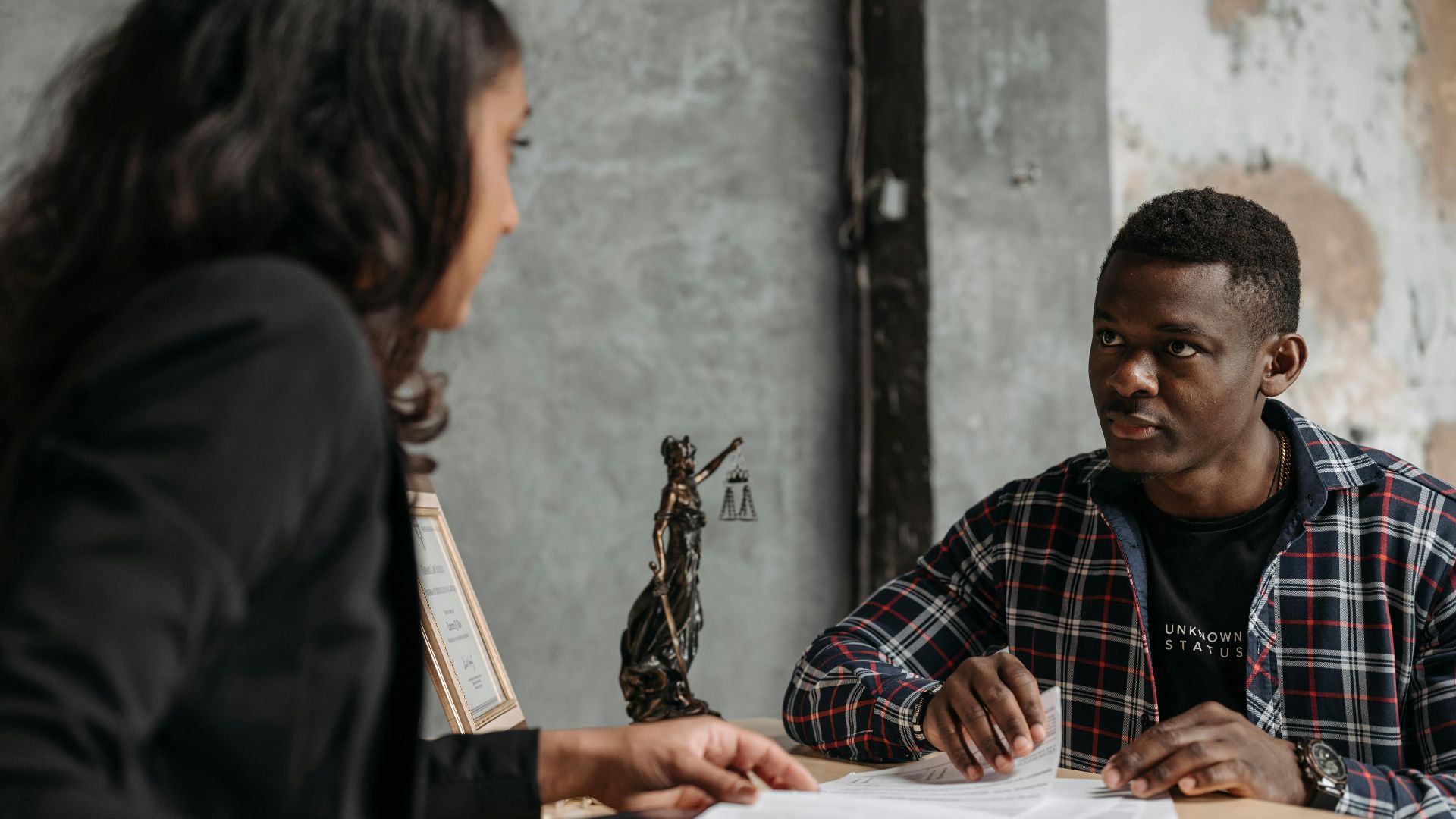 Business meeting between a lawyer and client in a professional office setting.