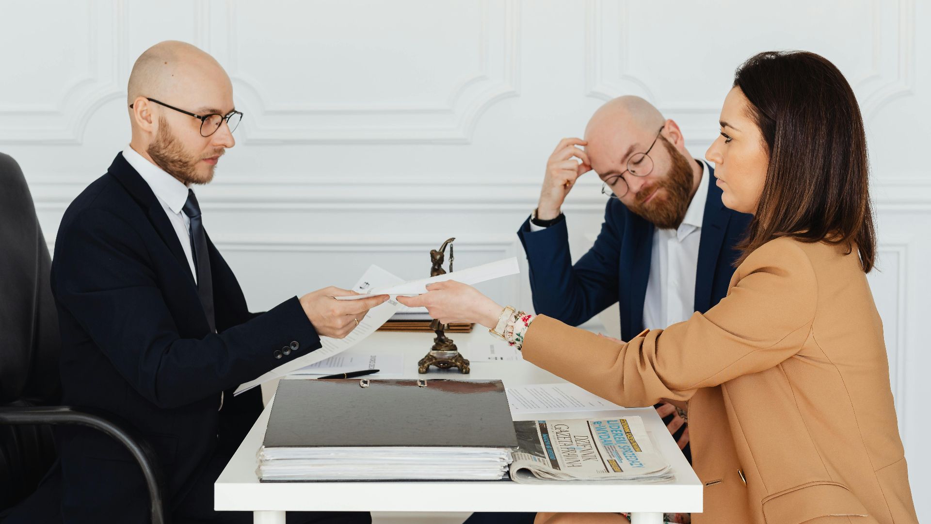 Professional meeting with lawyer and clients discussing documents in a modern office.