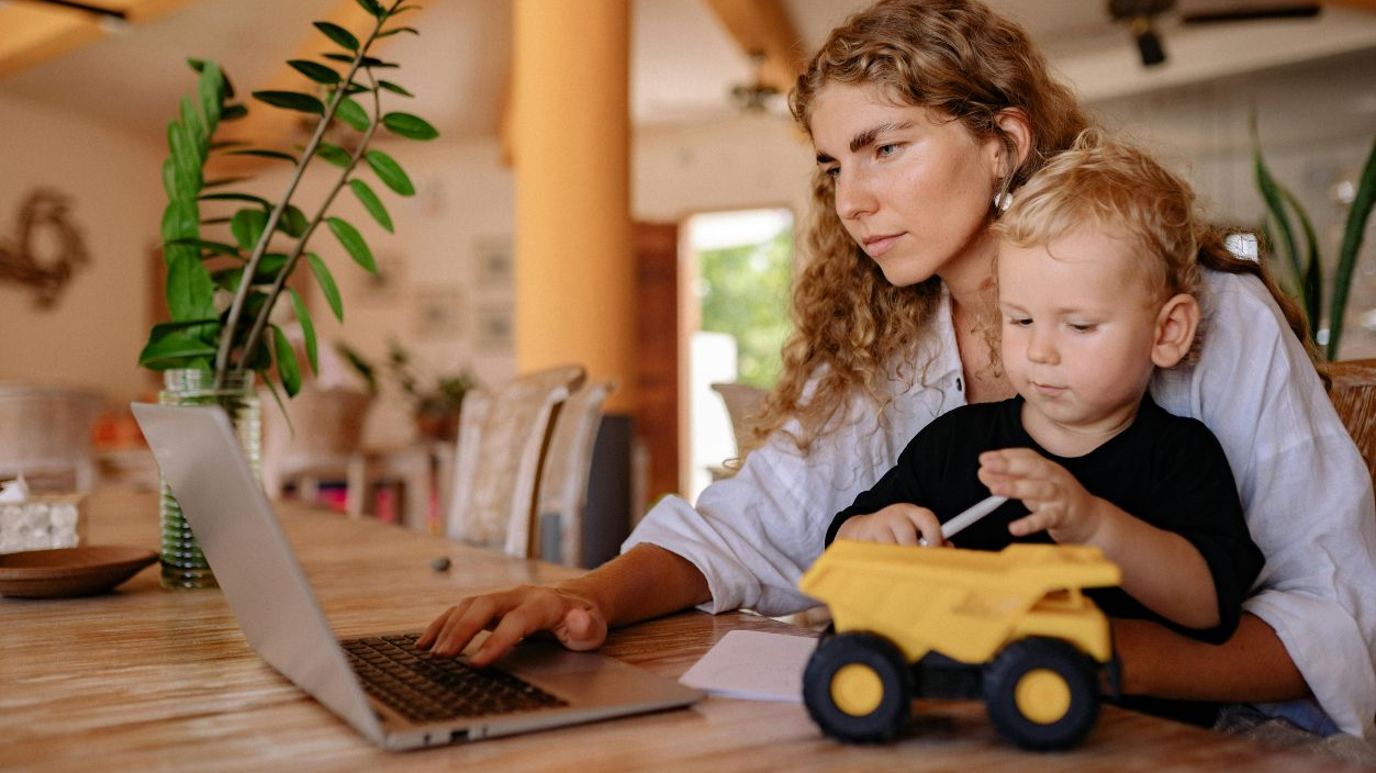 A Woman using a Laptop with her Son