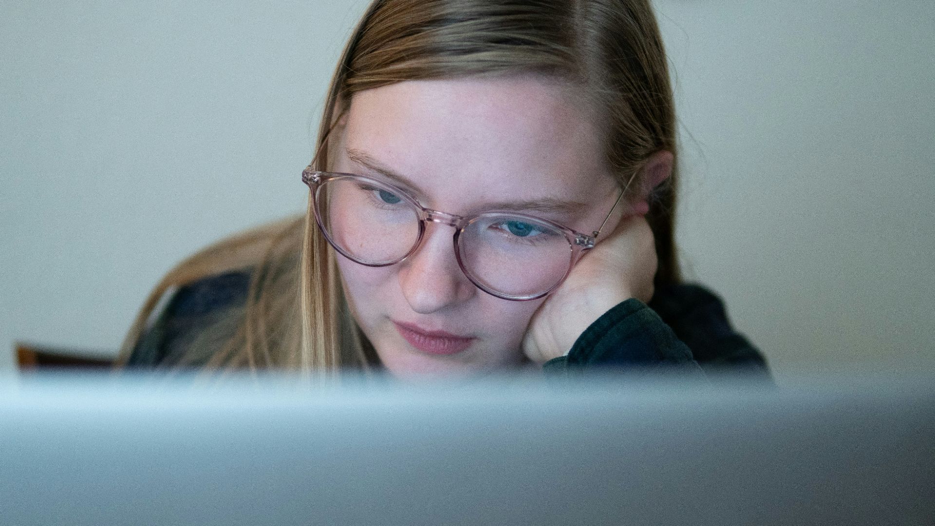 girl in blue jacket wearing brown framed eyeglasses