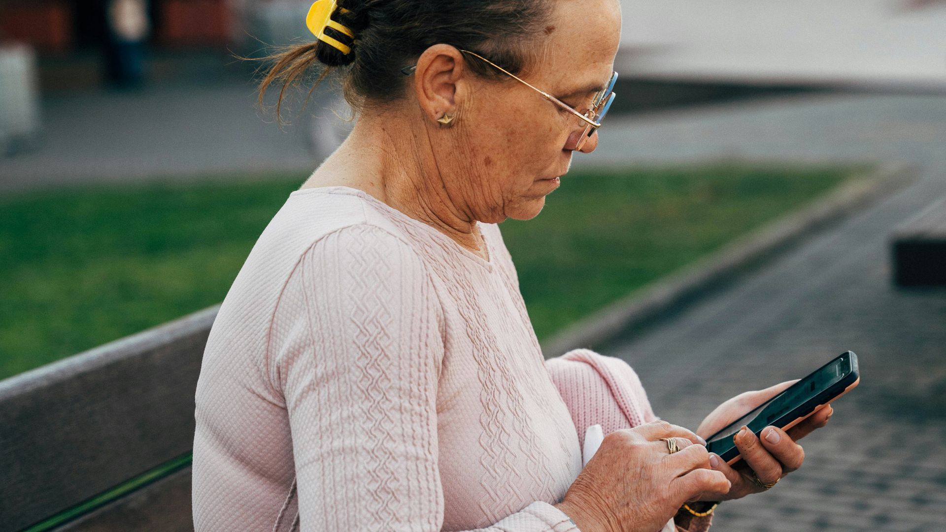 a woman sitting on a bench looking at her cell phone