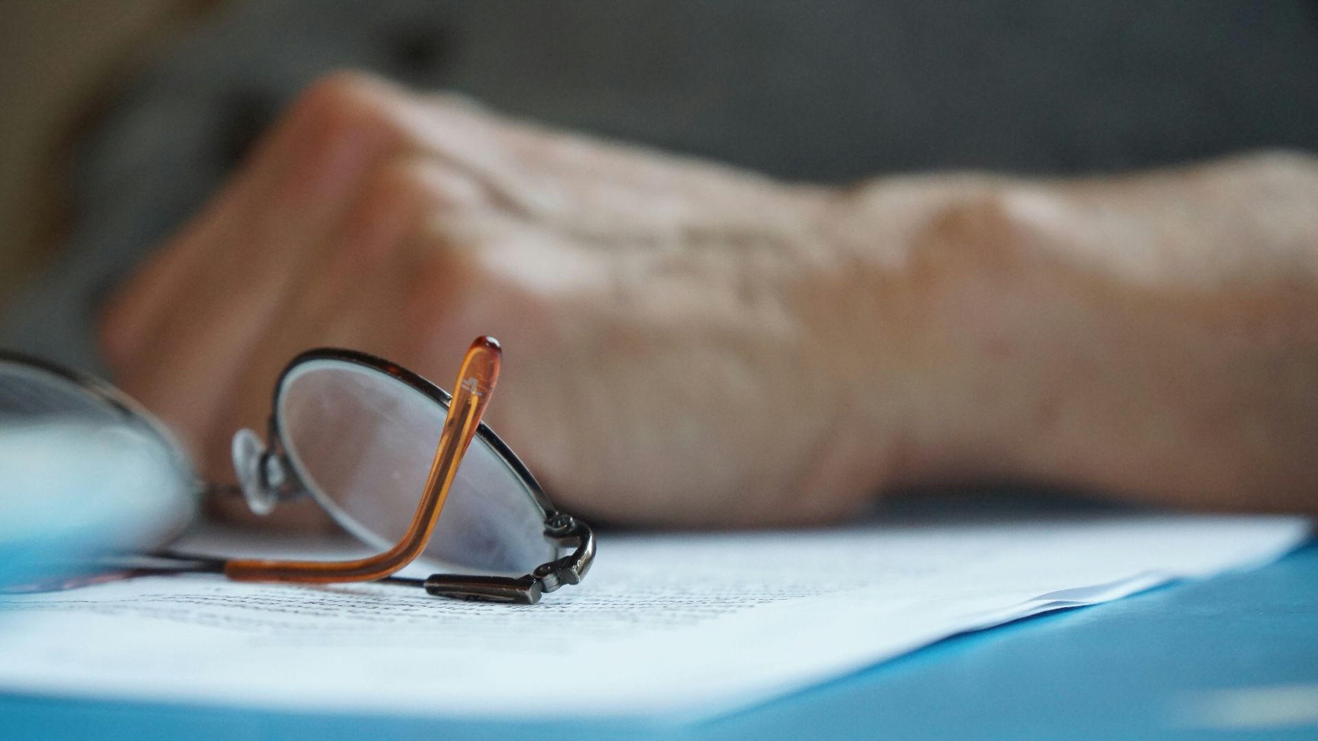 brown framed eyeglasses on blue textile