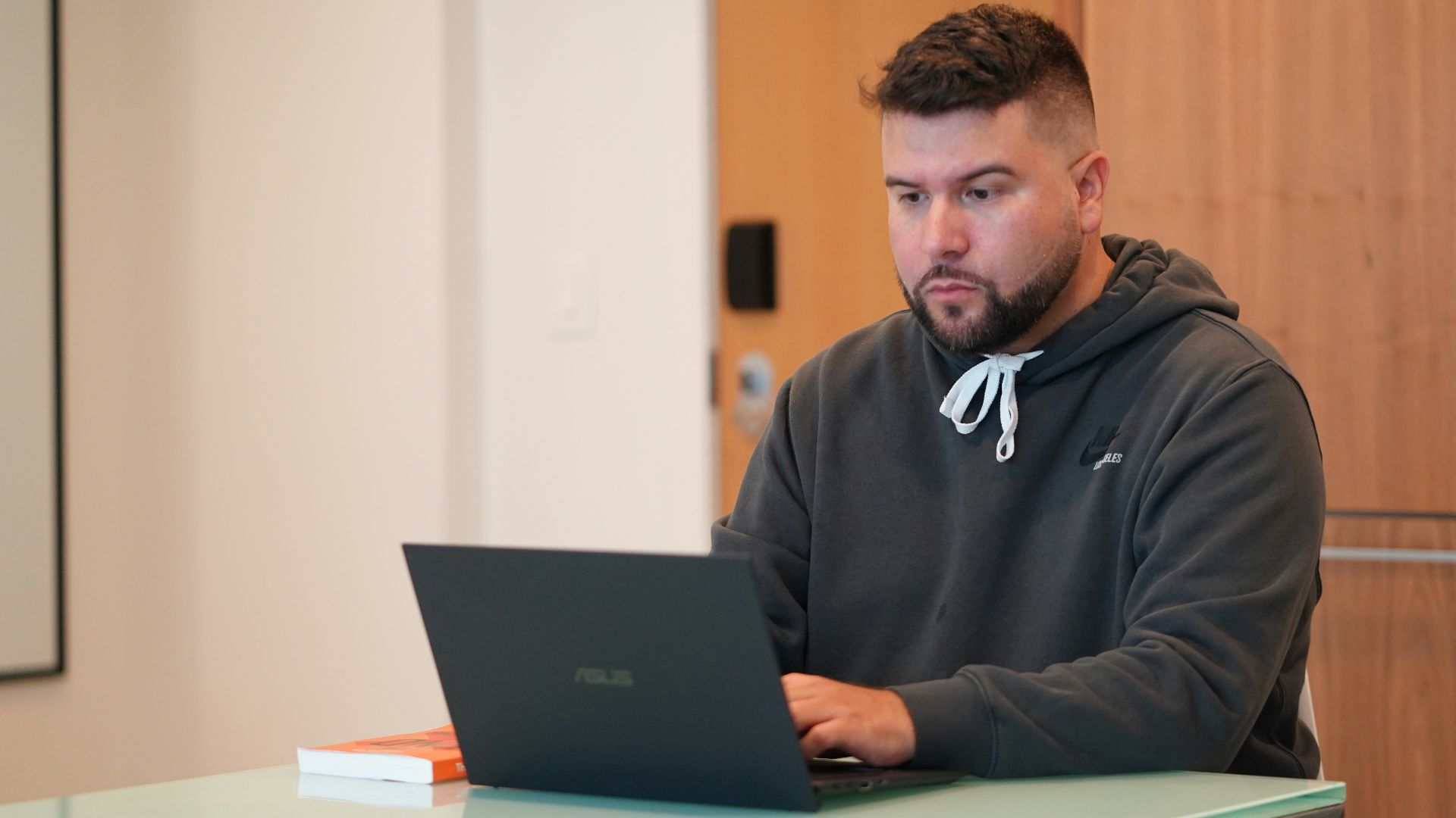 man in black nike jacket using macbook pro