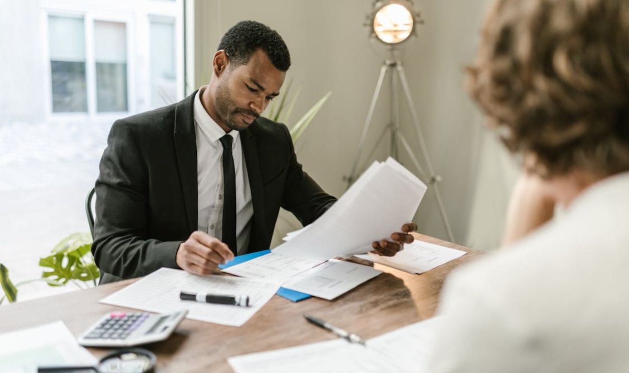Professional businessman reviewing documents at a desk in a modern office setting.