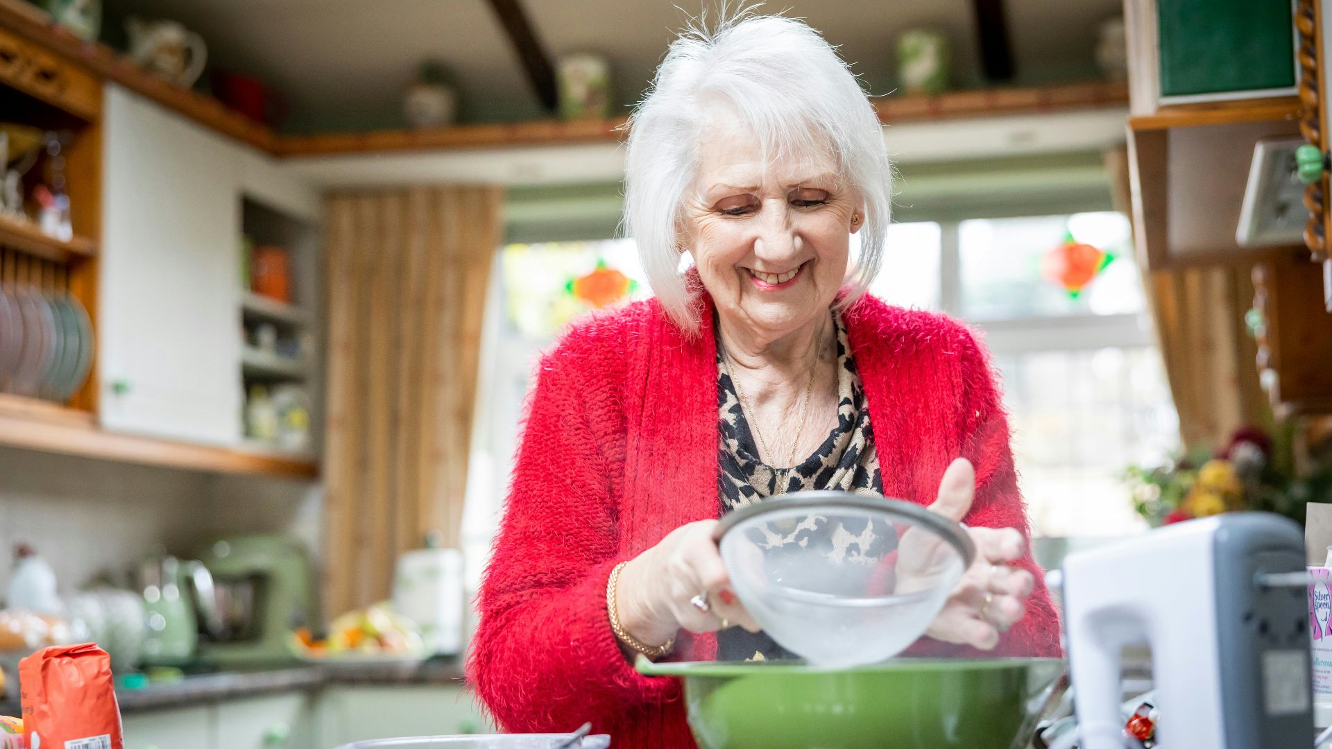 a woman mixing a bowl in a kitchen