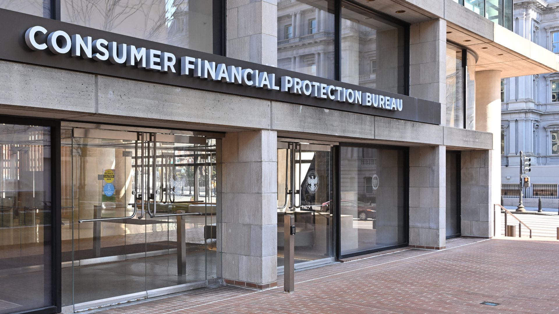 The entrance to the Consumer Financial Protection Bureau headquarters with the bureau's name above it. 1700 G Street NW, Washington, DC 20552.