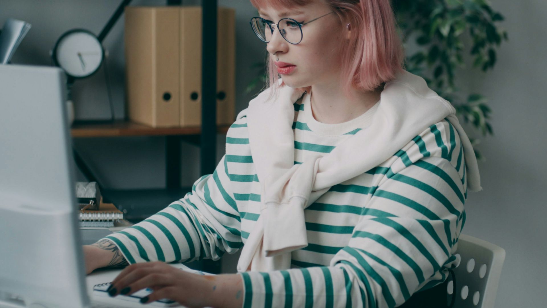 A woman sitting at a desk using a laptop computer