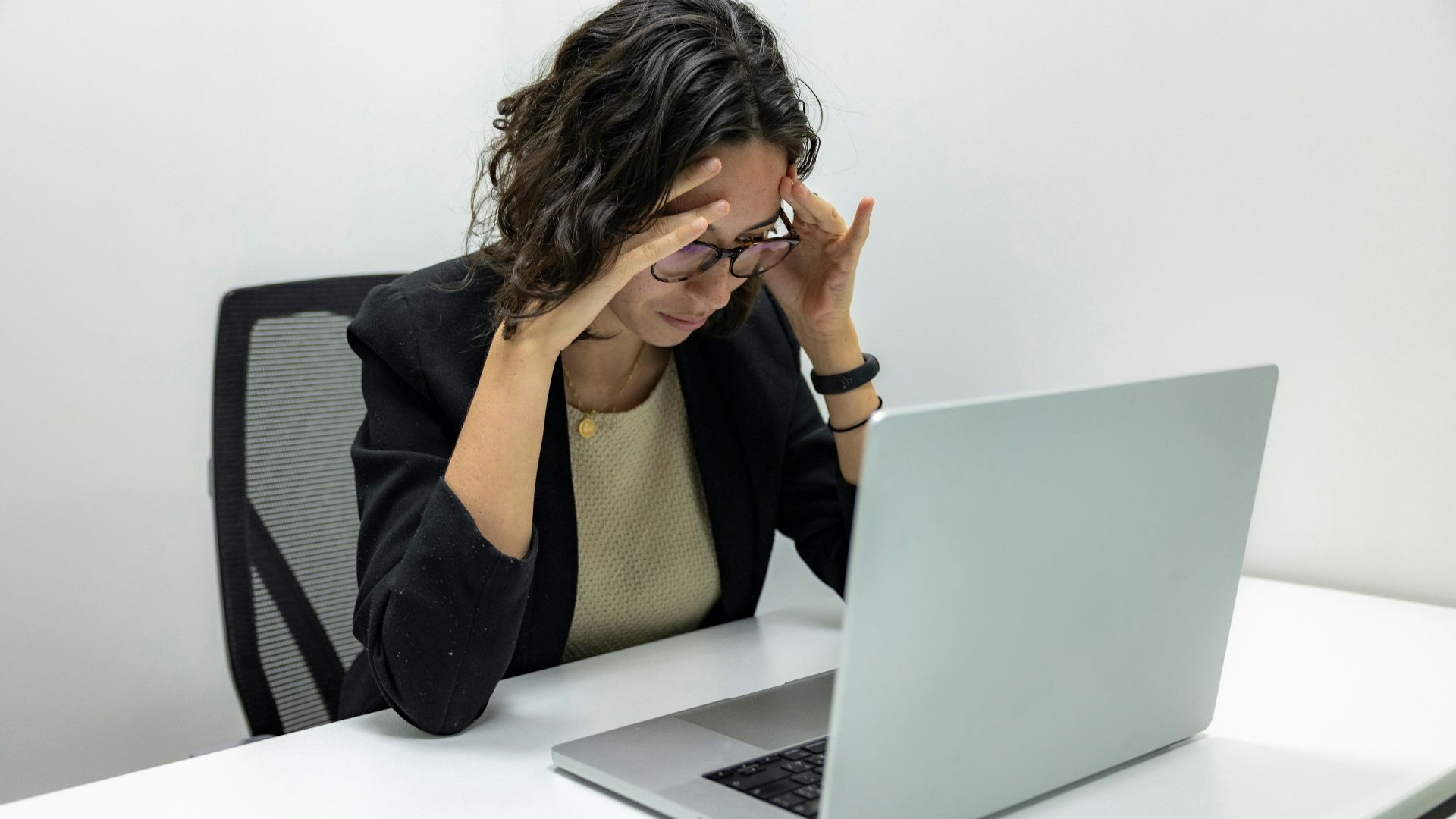a woman sitting in front of a laptop computer