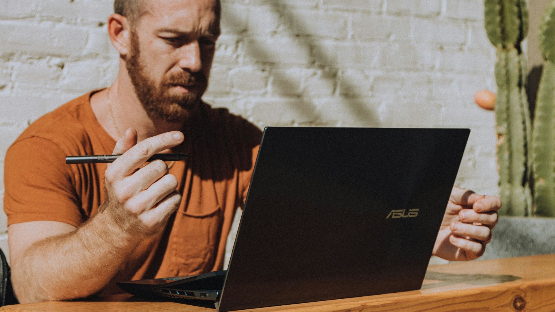 a man sitting at a table using a laptop computer