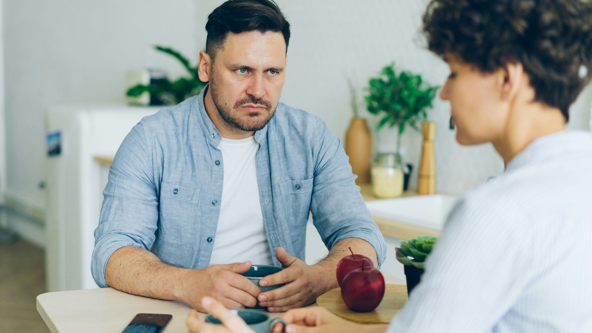 a man sitting at a table talking to a woman