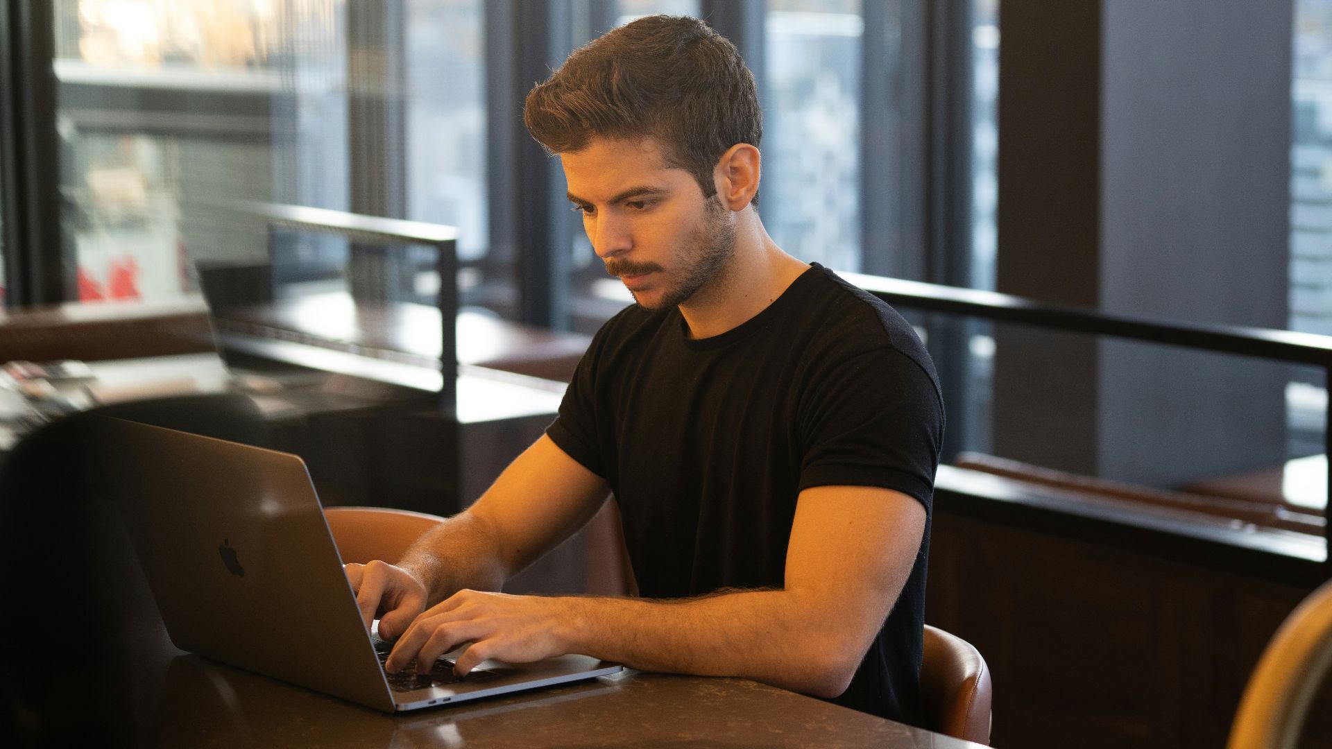 man in black crew neck t-shirt using macbook