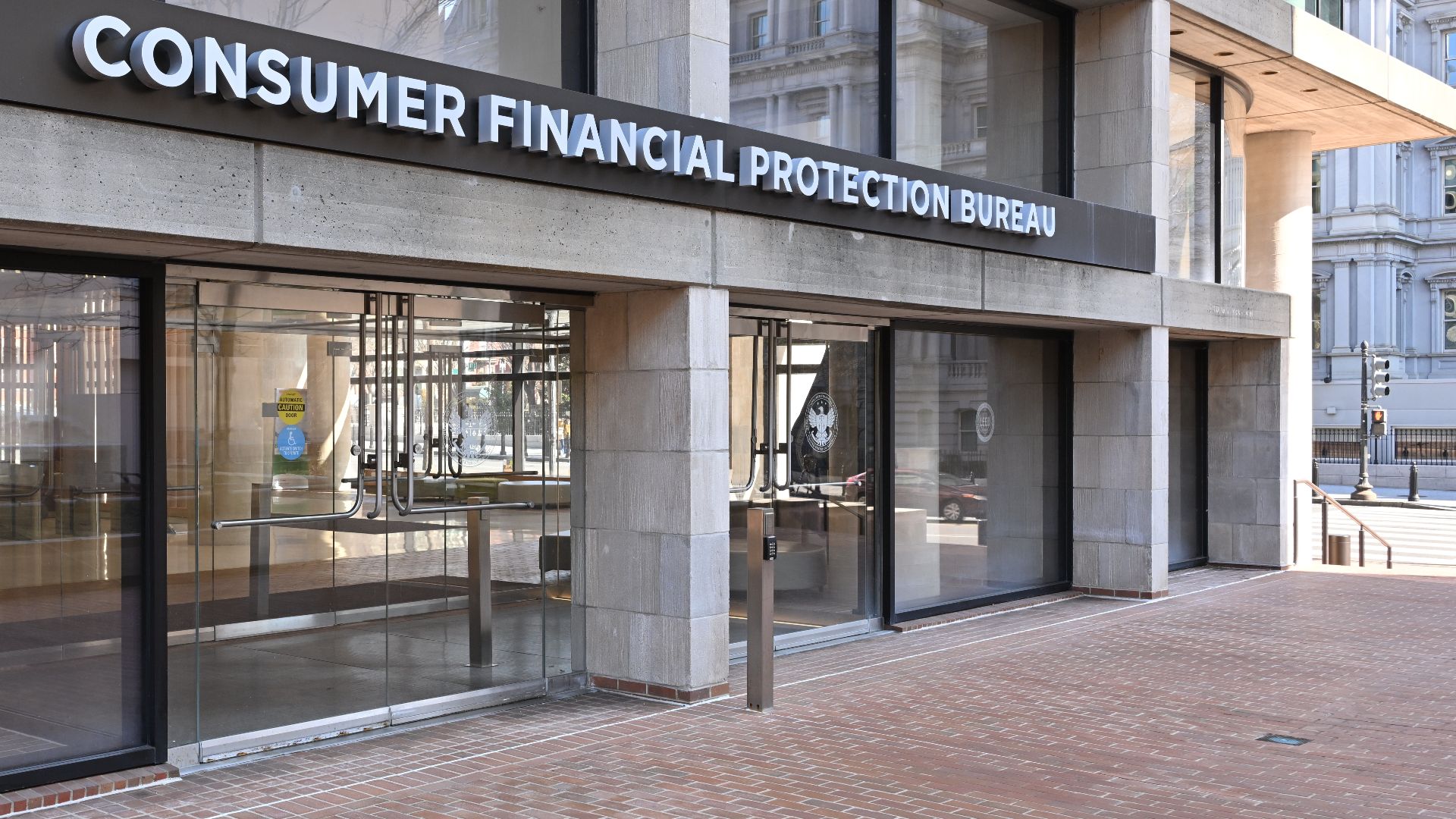 The entrance to the Consumer Financial Protection Bureau headquarters with the bureau's name above it. 1700 G Street NW, Washington, DC 20552.