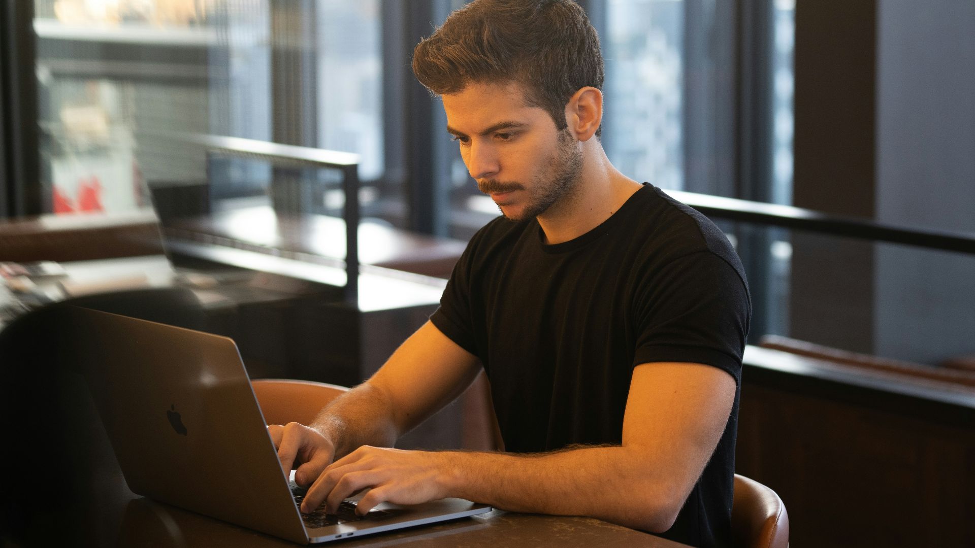 man in black crew neck t-shirt using macbook
