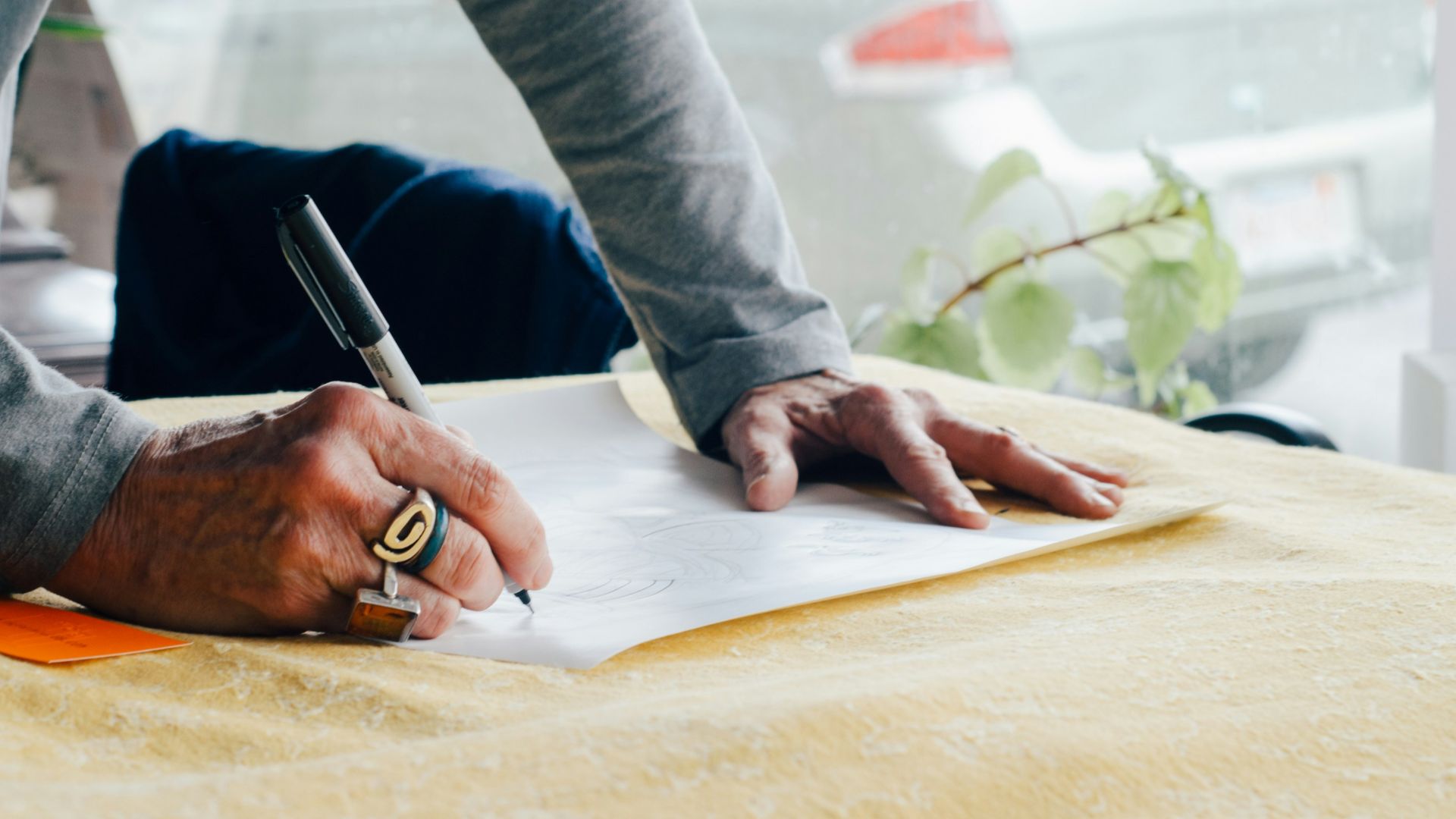 person writing on white plain paper on the table photography