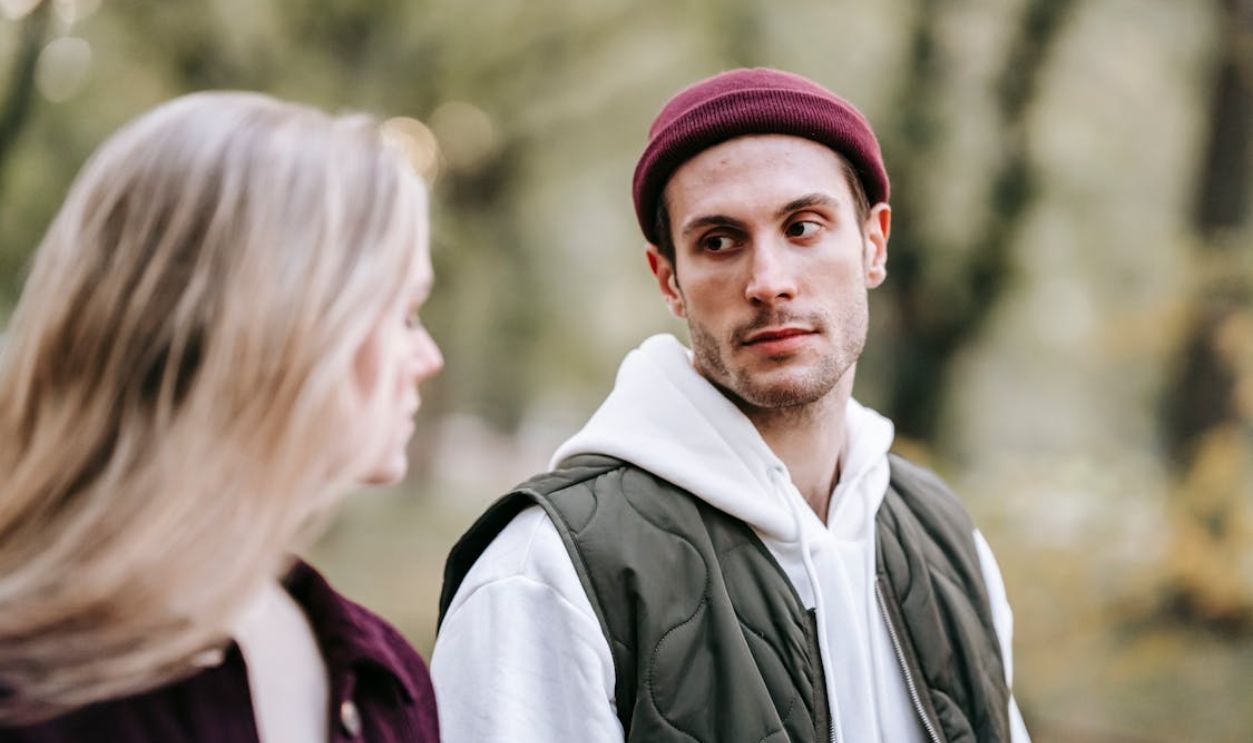 A young couple enjoying a peaceful walk in an urban park during daylight.