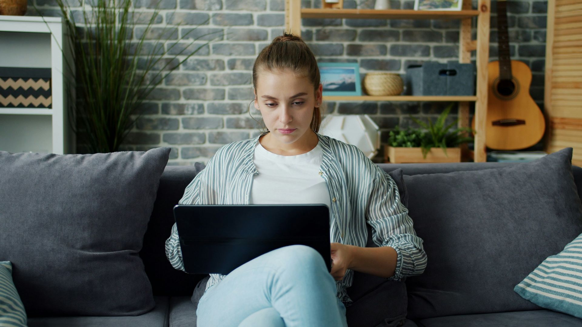 Young woman working on laptop on couch