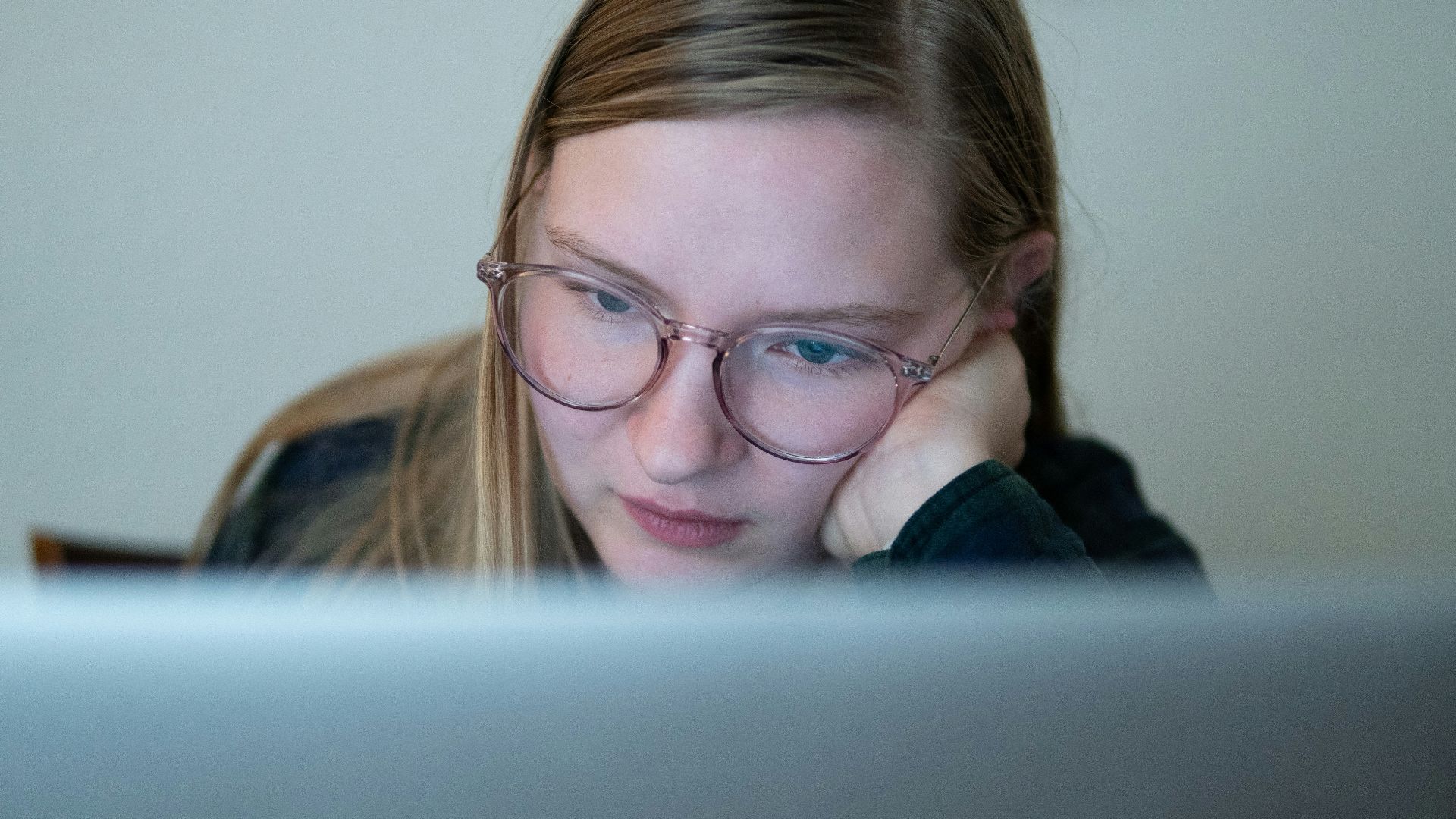 girl in blue jacket wearing brown framed eyeglasses