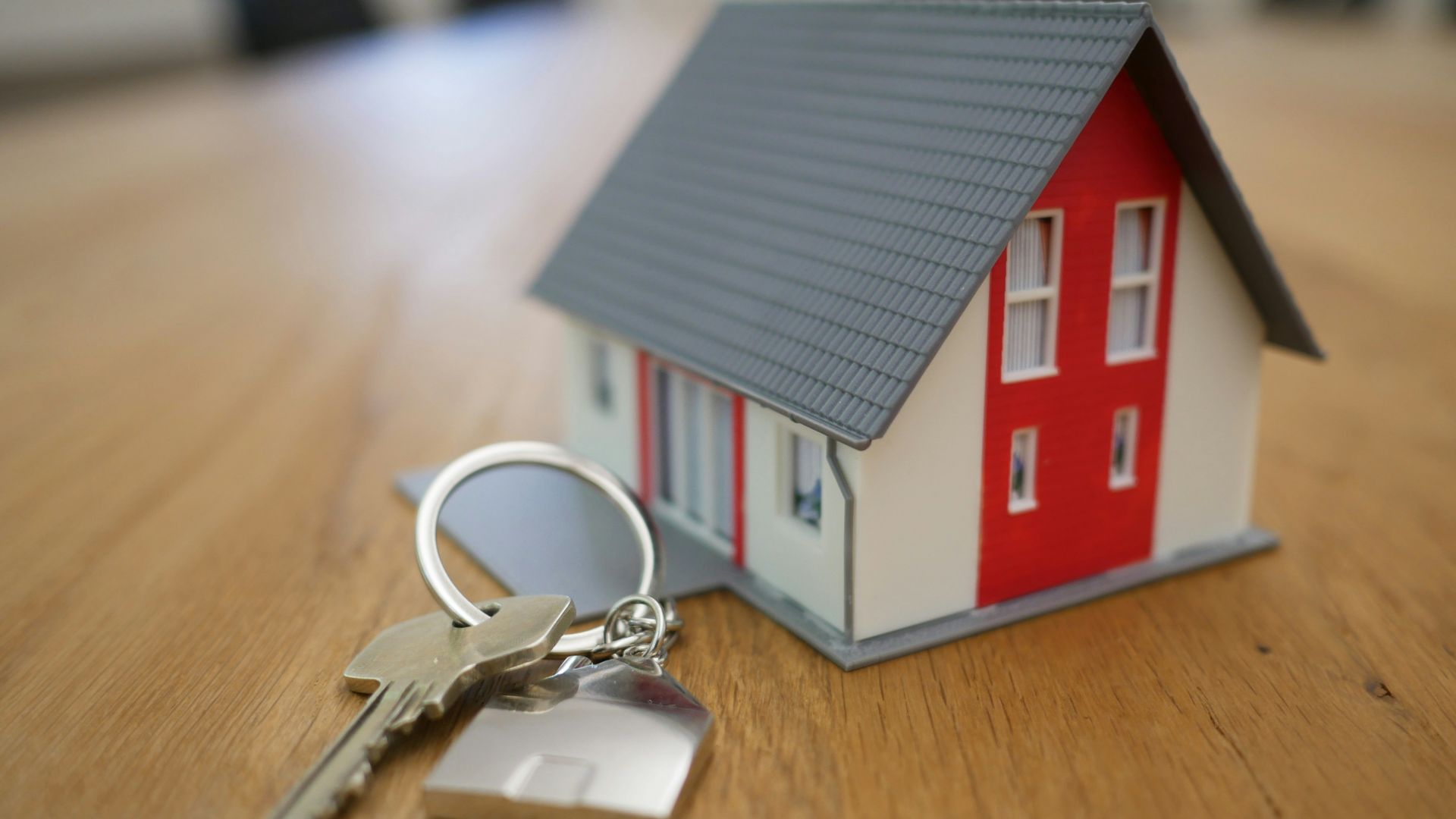 white and red wooden house miniature on brown table
