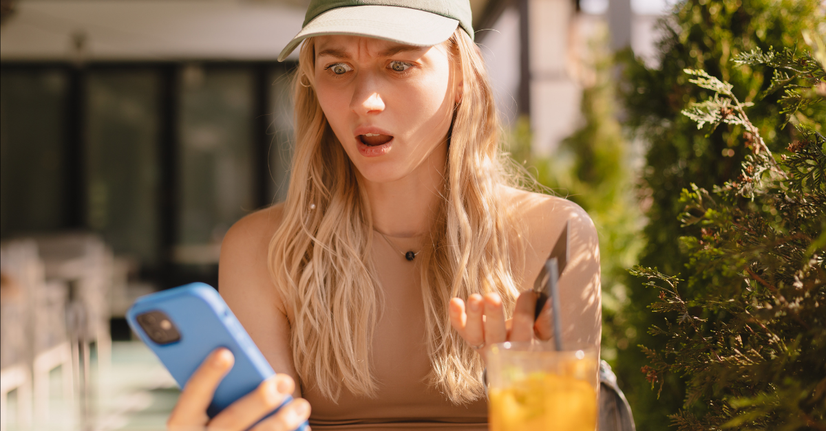 Online payment problem. Shocked frustrated young lady getting bank card declined blocked. Worried confused female overspending too much money from credit card at web shopping via cell sitting in cafe.