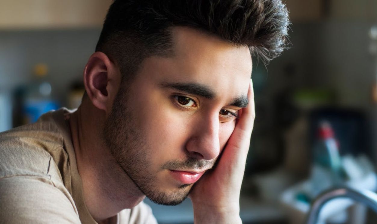Portrait of a thoughtful young man in casual wear, indoors with soft lighting
