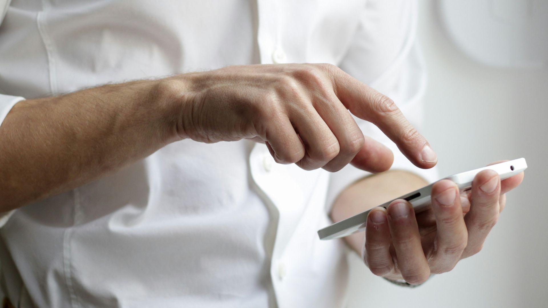 person holding white Android smartphone in white shirt