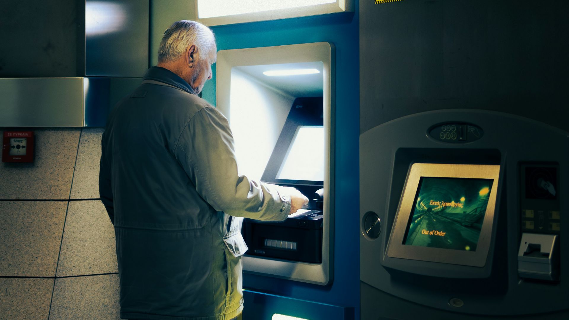 A man standing in front of a atm machine