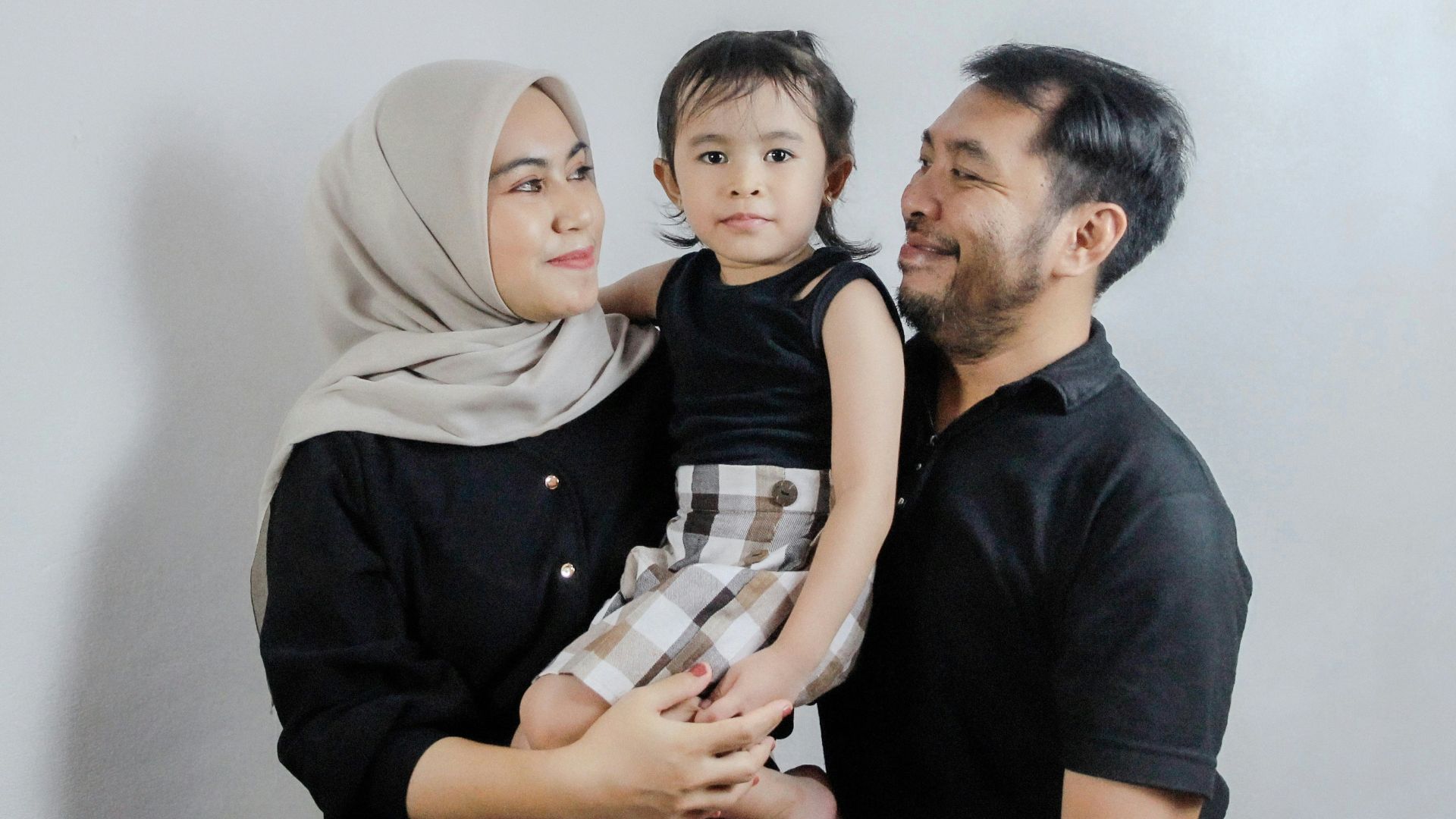 A man and a woman holding a small child
