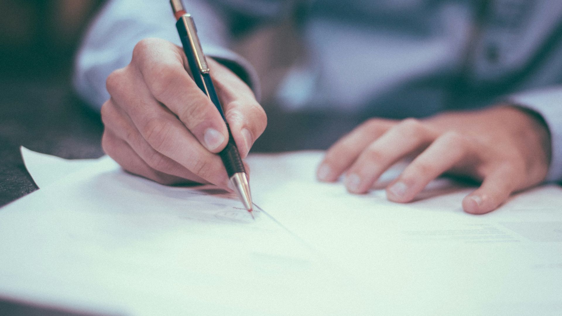 man writing on paper