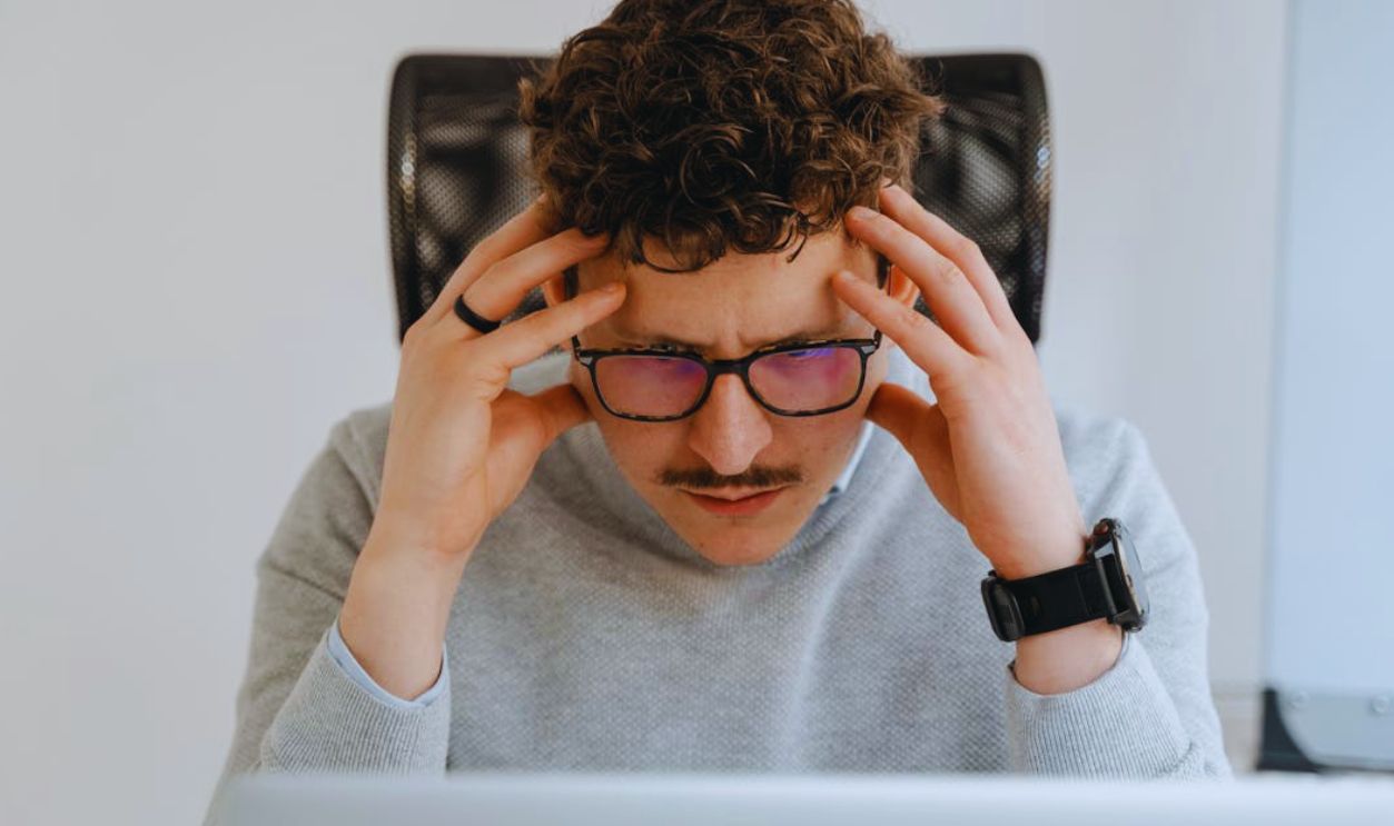 A serious businessman focusing intently on his work, using a laptop indoors
