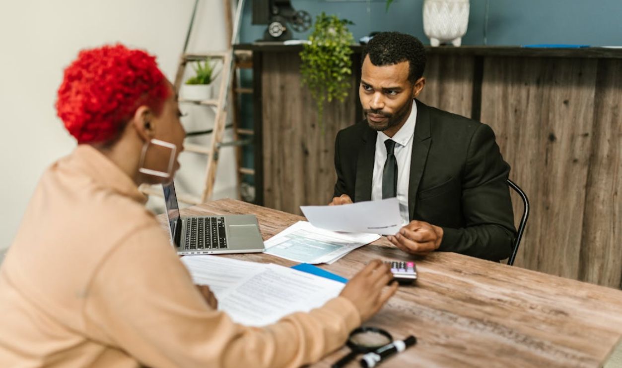 A discussion between two professionals focusing on financial documents in a modern office setting.