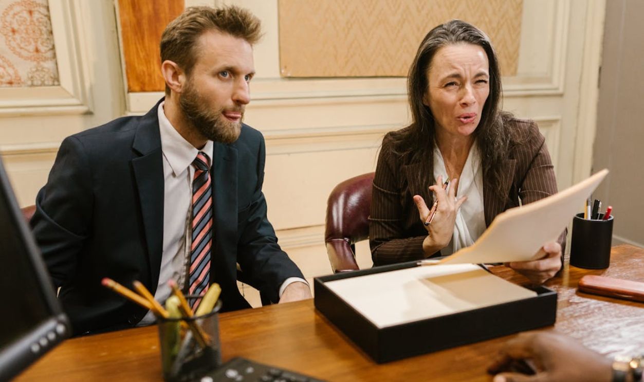 Lawyers discussing legal documents in a professional office setting.