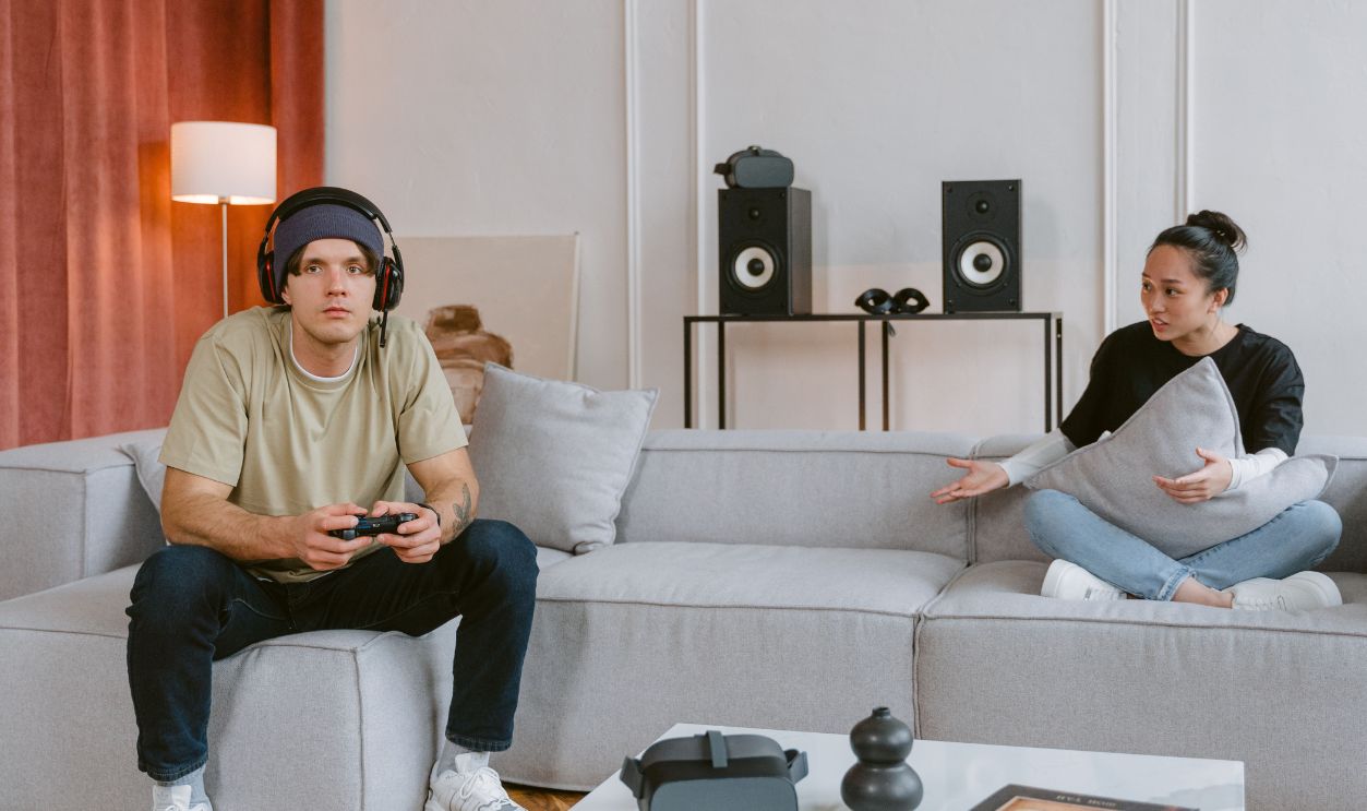 Couple engaging in video gaming in a modern living room setting, highlighting leisure and technology