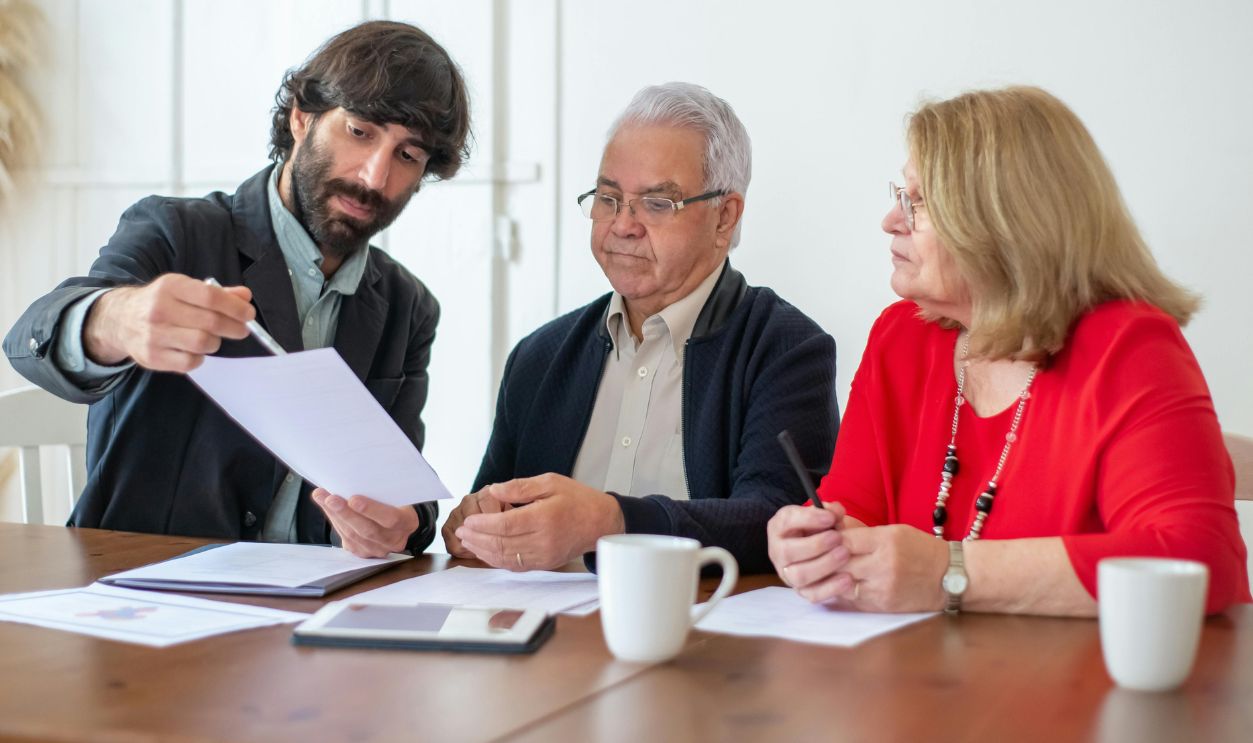 Elderly couple discussing documents with advisor 