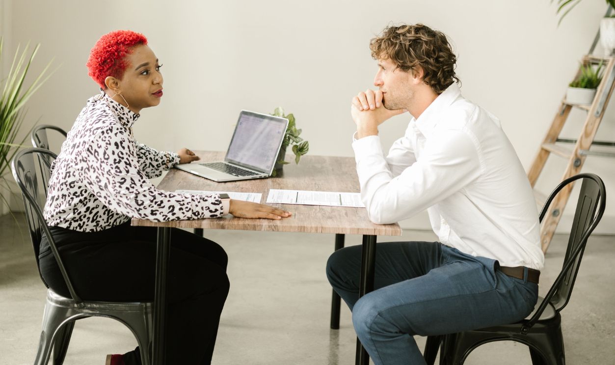 Colleagues engaged in discussion at a table in a modern office 